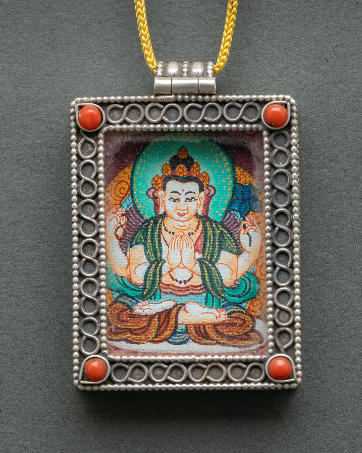 Handcrafted Chenrezig locket from nepal with silver filigree and sacred buddhist art.