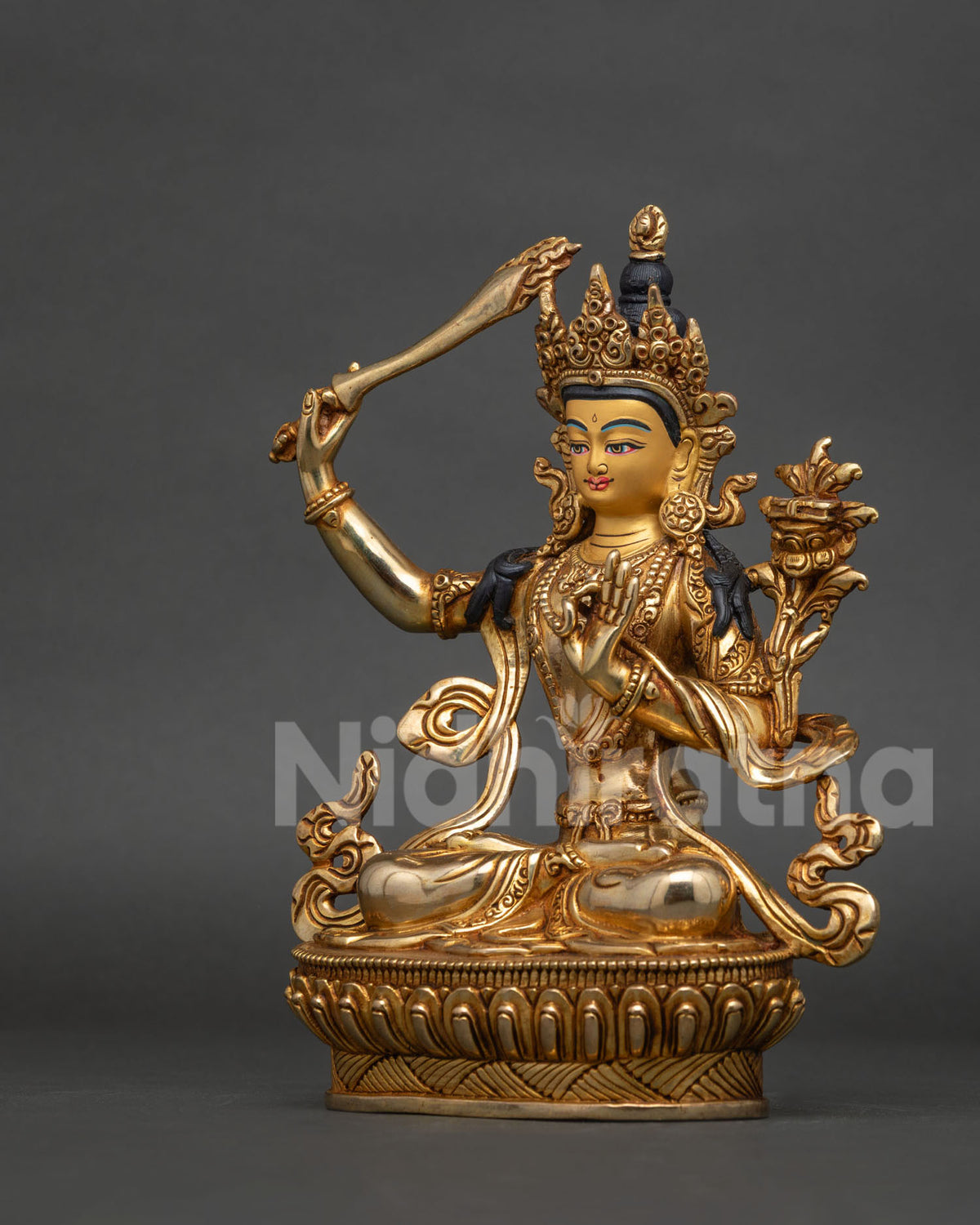 Handcrafted manjushri copper statue with hand carved silk garment and gold gilded finish.