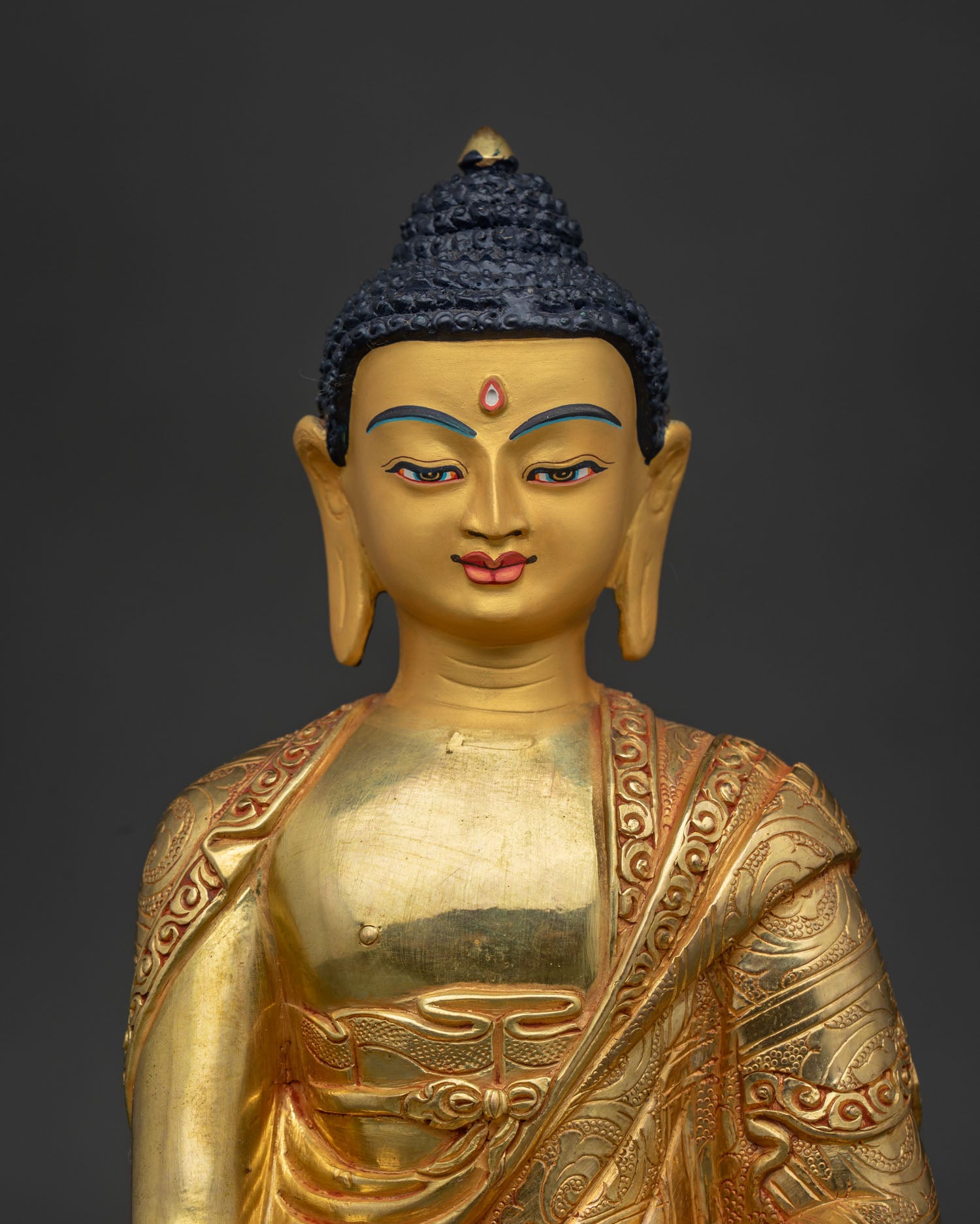 Handcrafted Shakyamuni Buddha statue close up with gold painted face details.