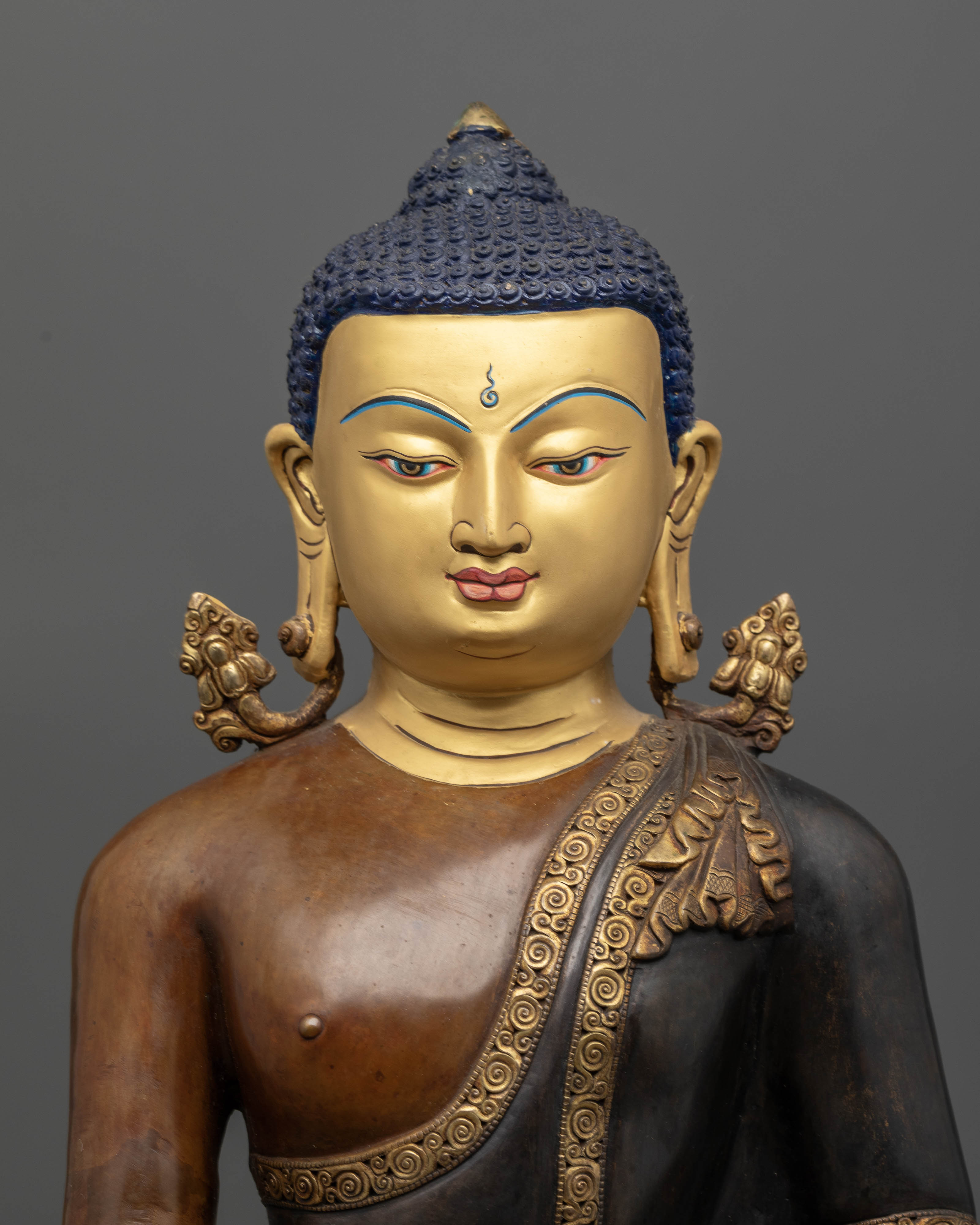 Handcrafted Shakyamuni Buddha statue with gold painted face and oxidized copper finish