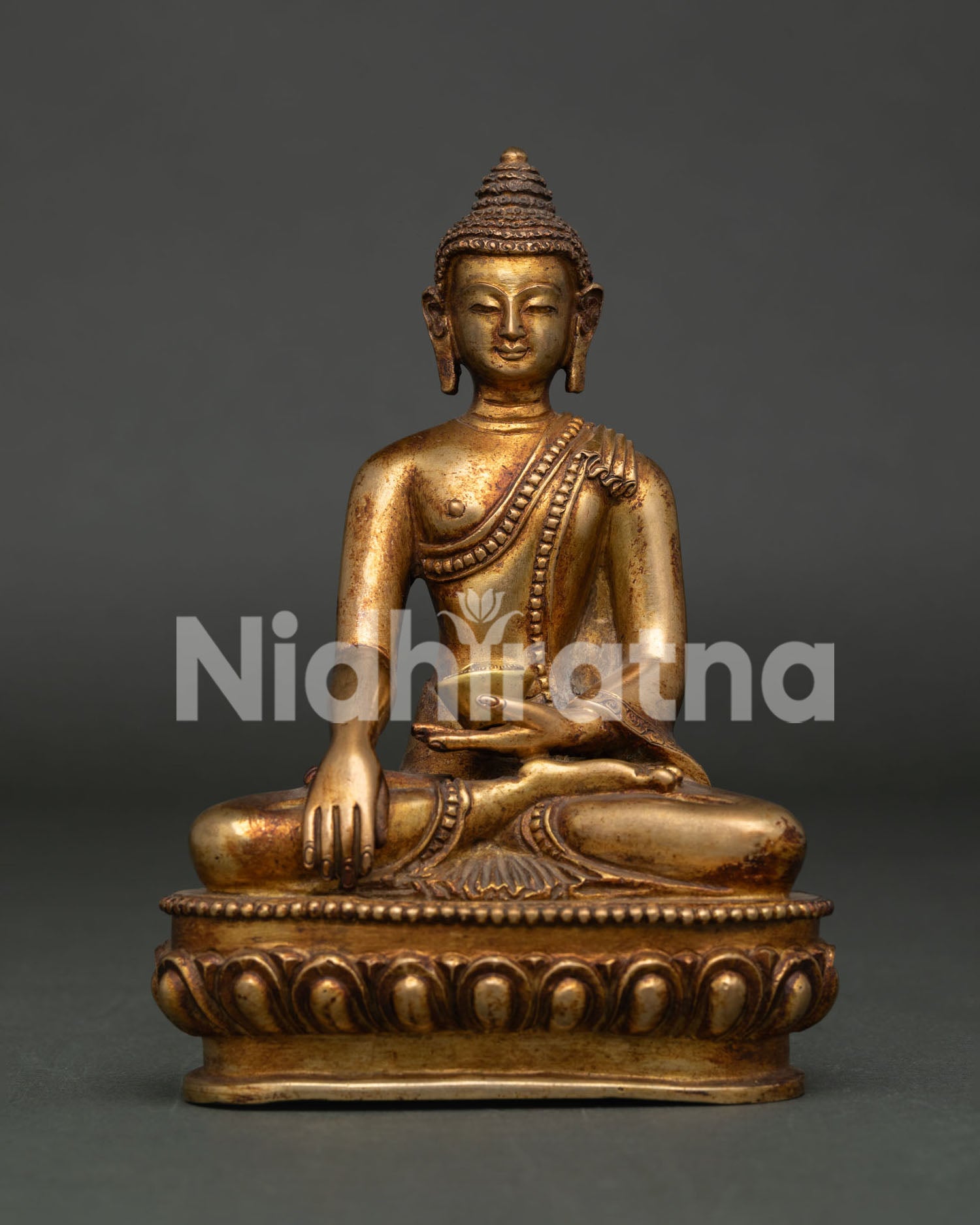 Himalayan Shakyamuni Buddha statue holding traditional begging bowl and lotus base.
