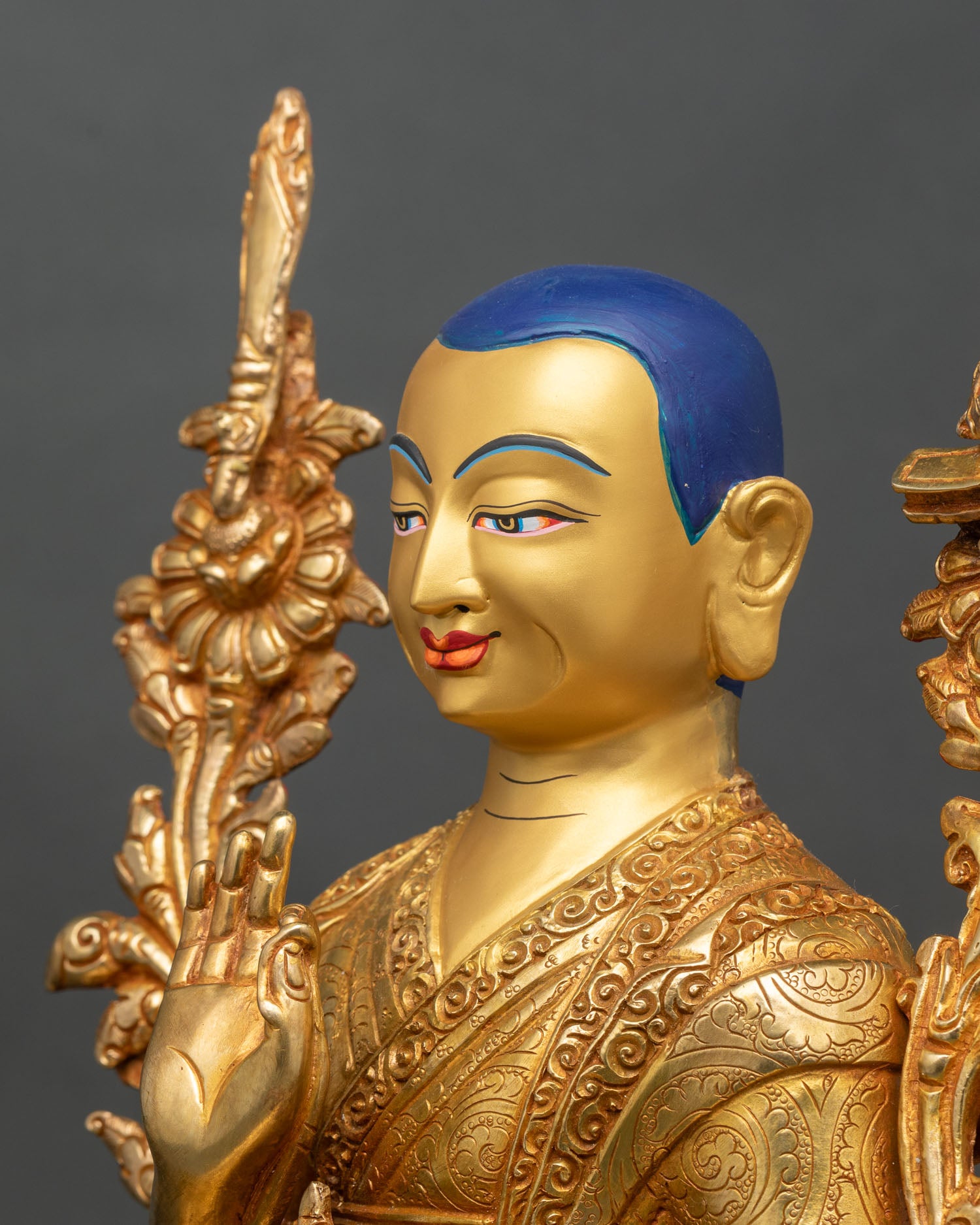 Side detail of Je Tsongkhapa statue showing engraved robes and lotus stalk