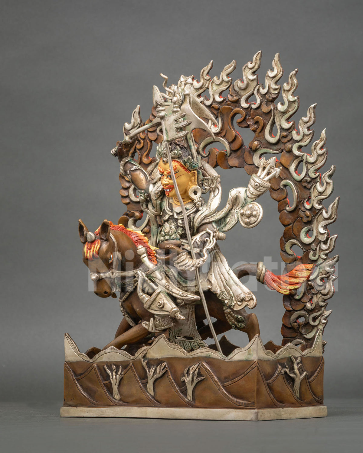 King Gesar statue with stylized mountain motifs on decorative base.
