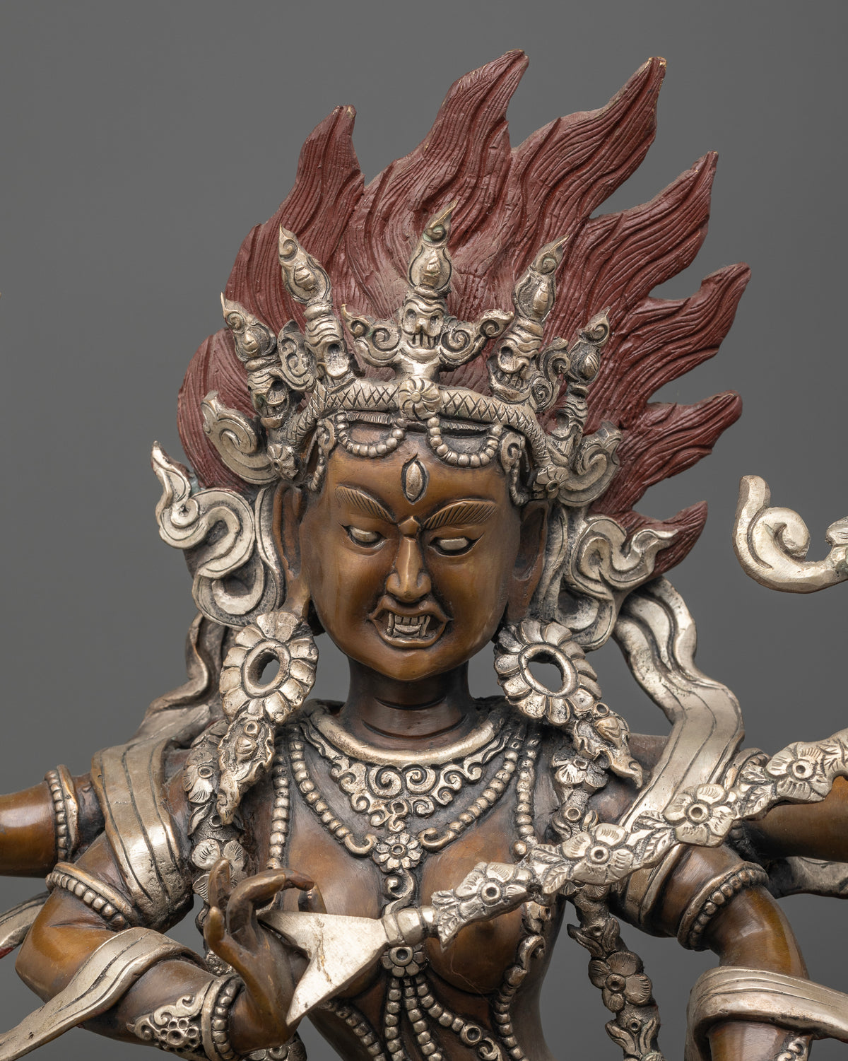 Kurukulla statue holding a bow and arrow sword and rosary with a finely carved flowing robe
