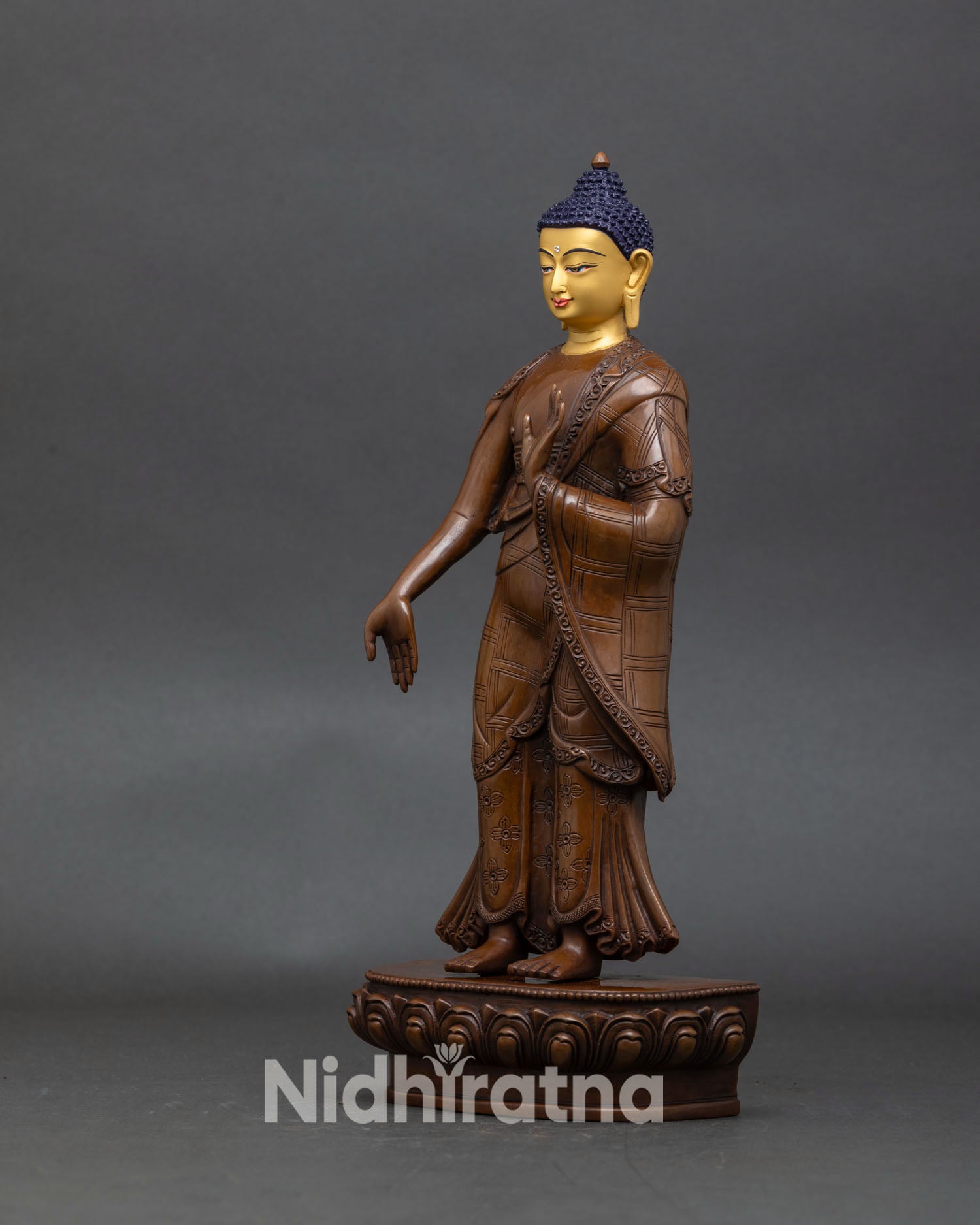 left profile of dipankara buddha standing statue with oxidized copper and gold face