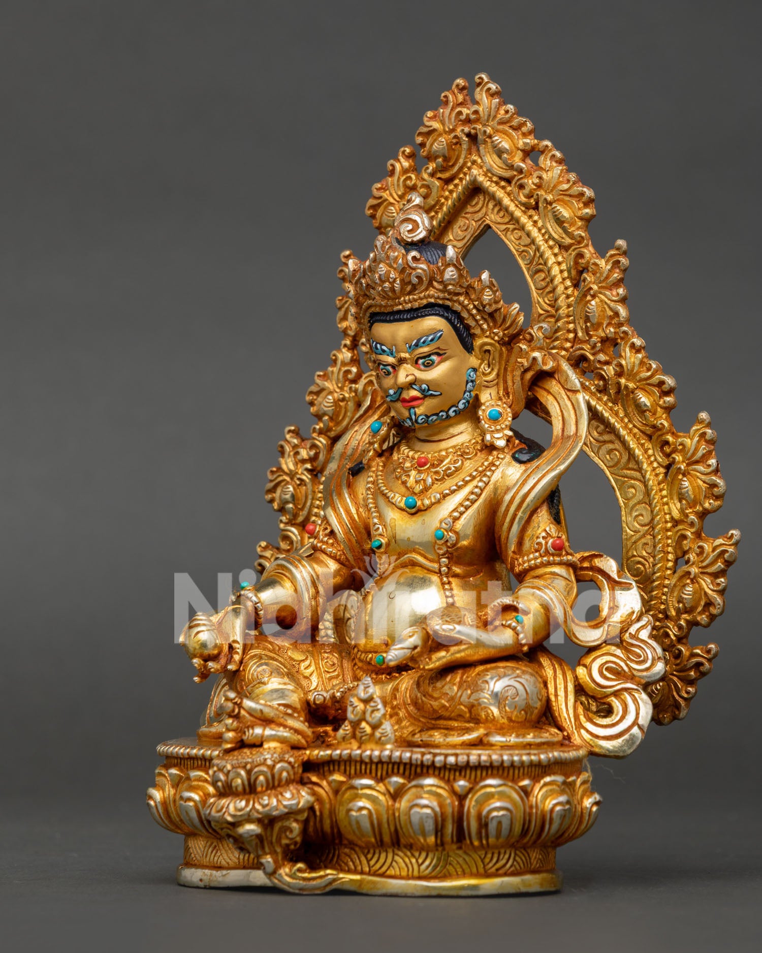Left profile of handmade Dzambhala statue featuring copper body and gold gilding