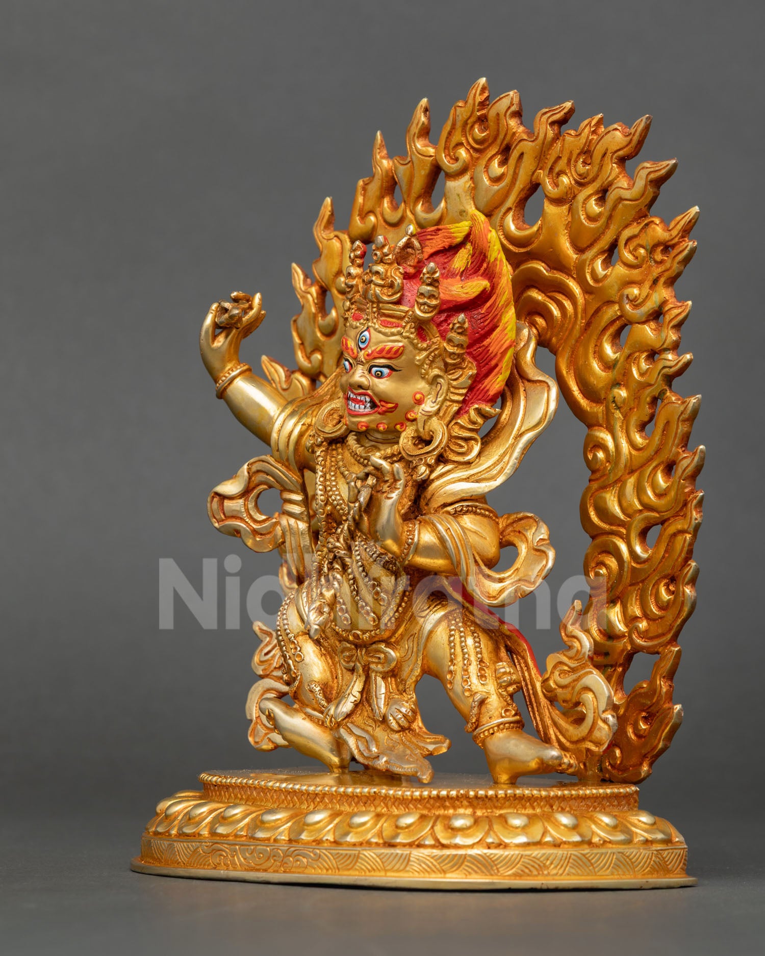 left profile of vajrapani protector statue with gold gilding and intricate lotus base details