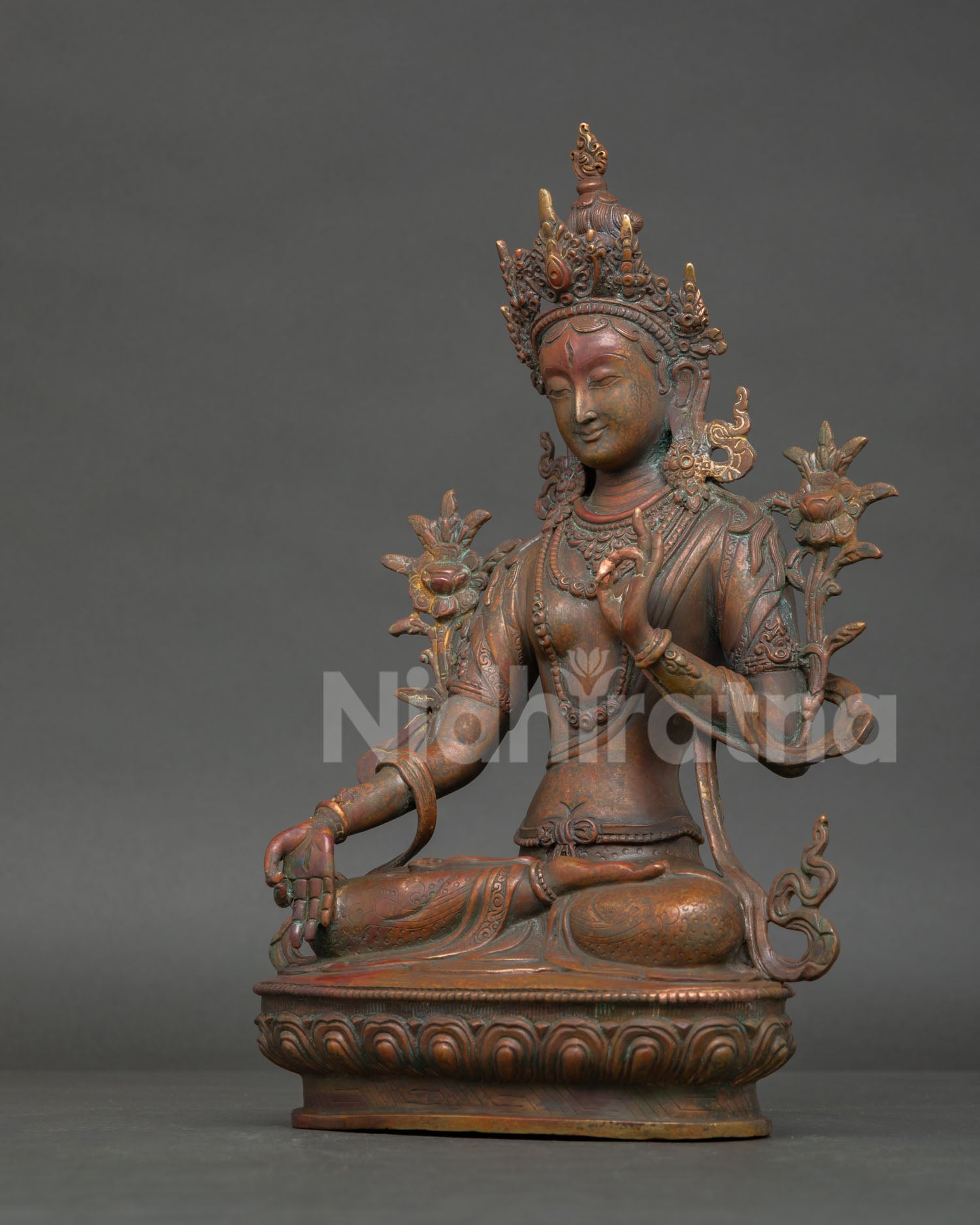 left profile of white tara buddhist statue with elegant lotus seat and spiritual design