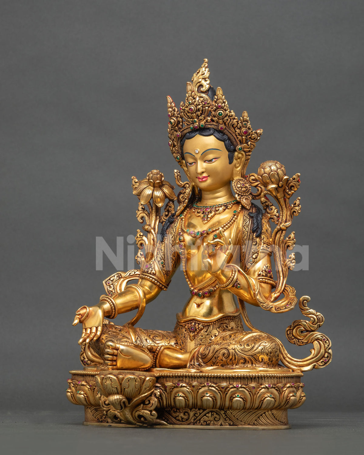 Left side view of Buddhist Green Tara statue from Nepal with lotus flowers and gold gilding
