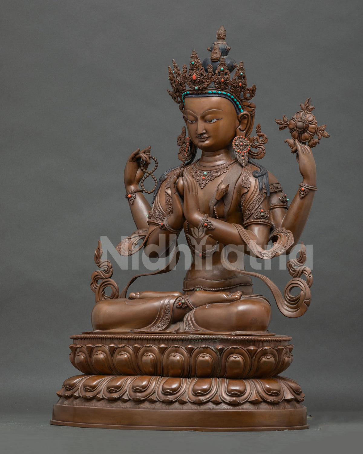 Left side view of Chenrezig statue showing rosary hand and flowing robe