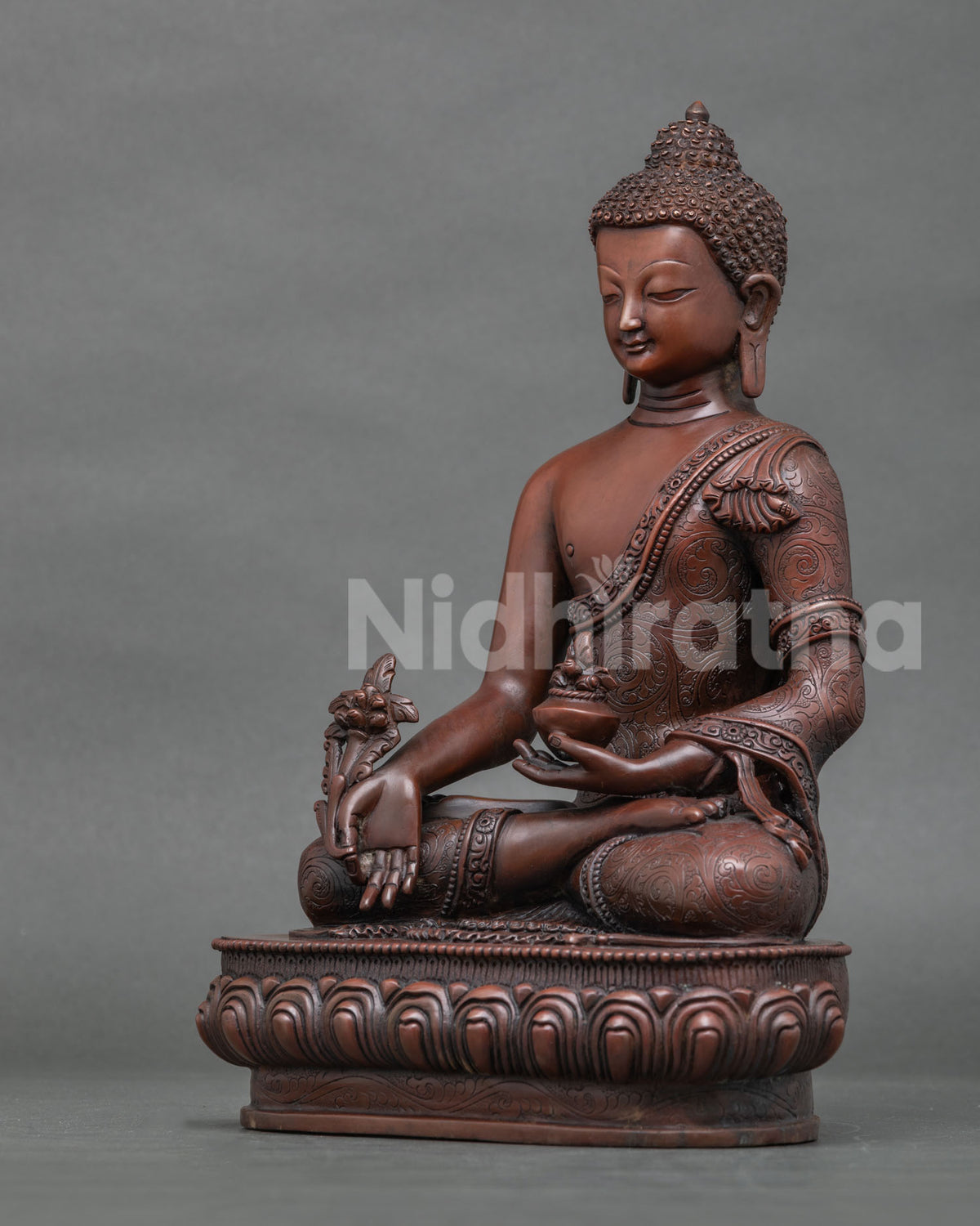 Left side view of copper Bhaisajyaguru Medicine Buddha statue on lotus pedestal