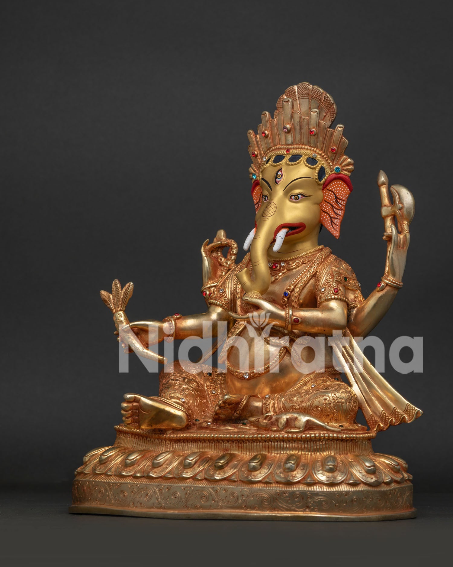 Left side view of Ganesh idol showing mala, axe, broken tusk and modak in hand