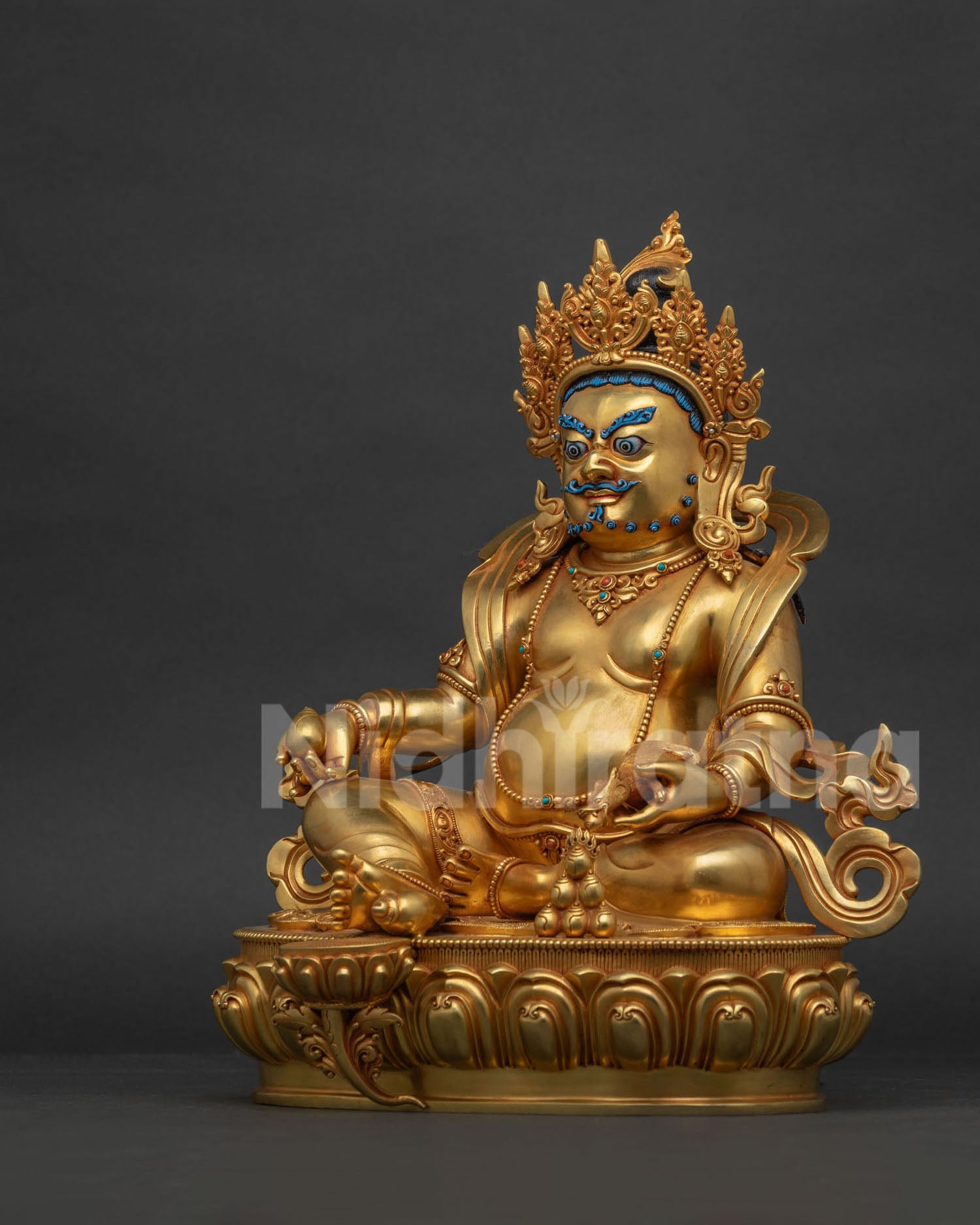 Left side view of gold fire-gilded Dzambhala statue on carved lotus base