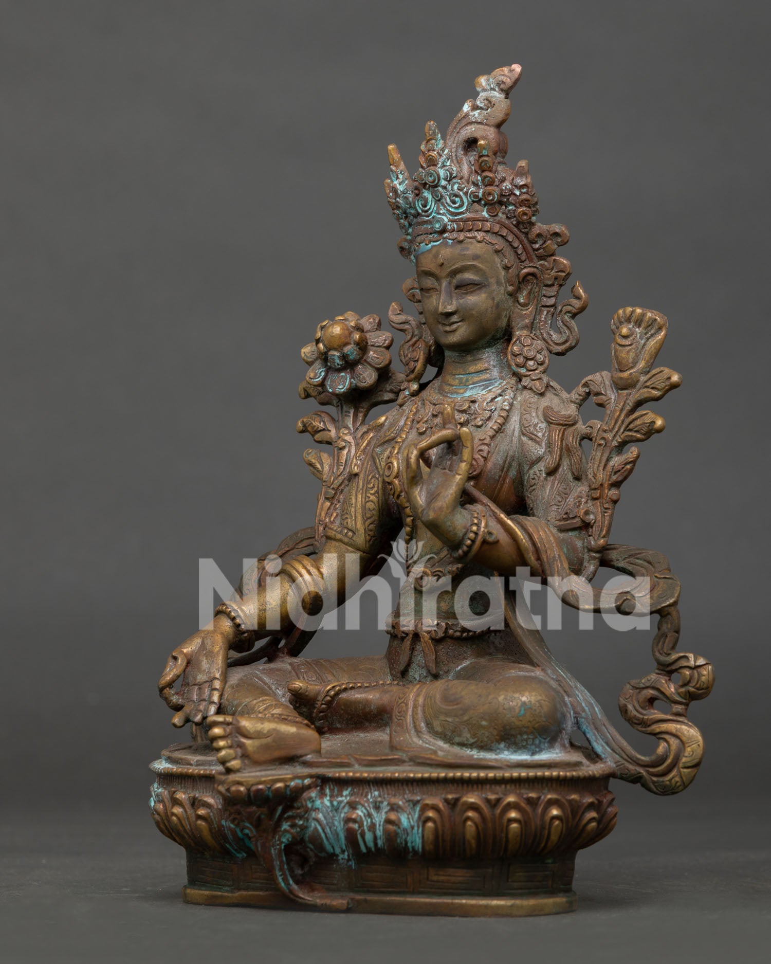 left side view of green tara buddhist statue displaying handmade copper details and antique patina finish