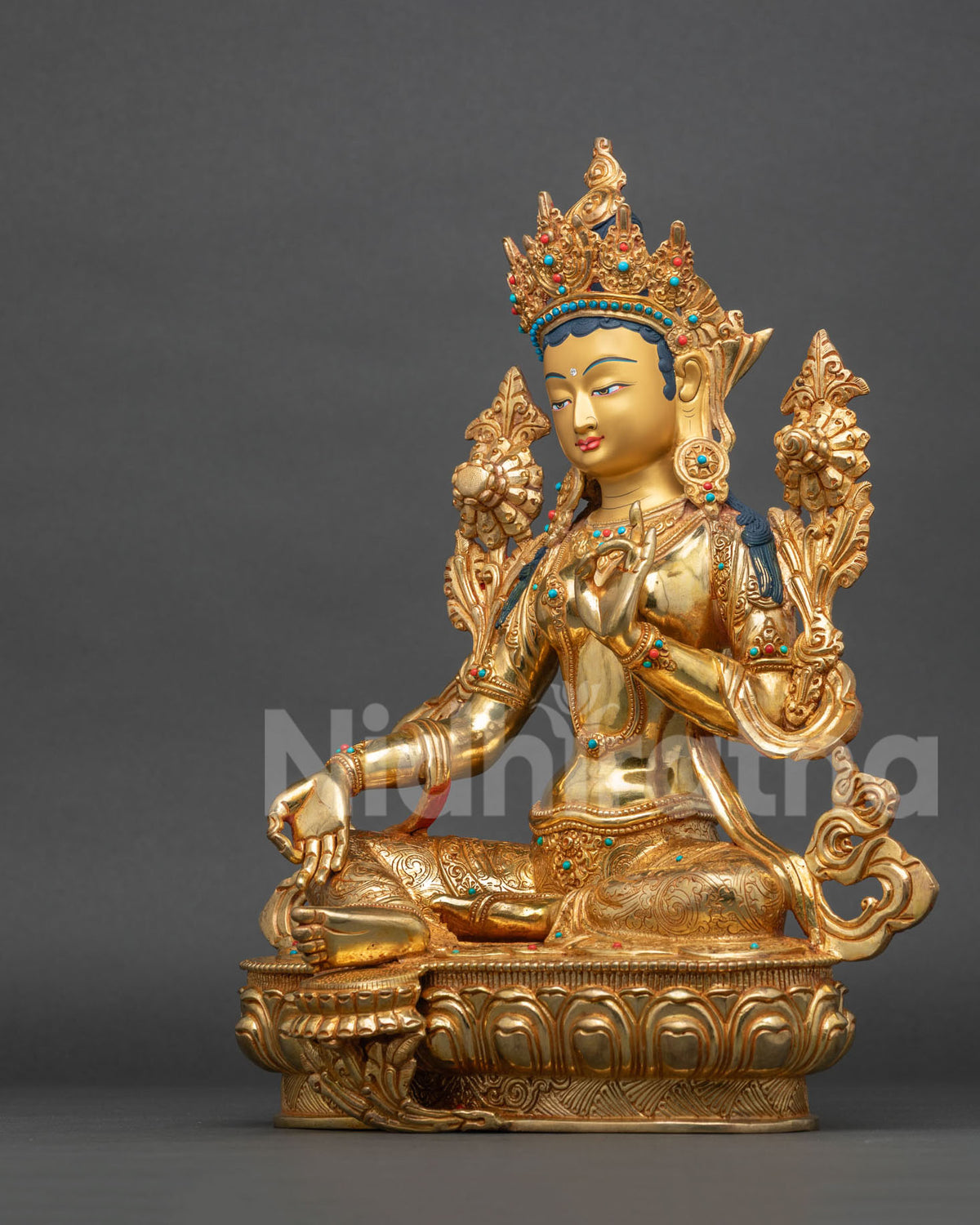 Left side view of Green Tara statue holding an utpala flower, lost-wax cast copper with 24K gold gilding
