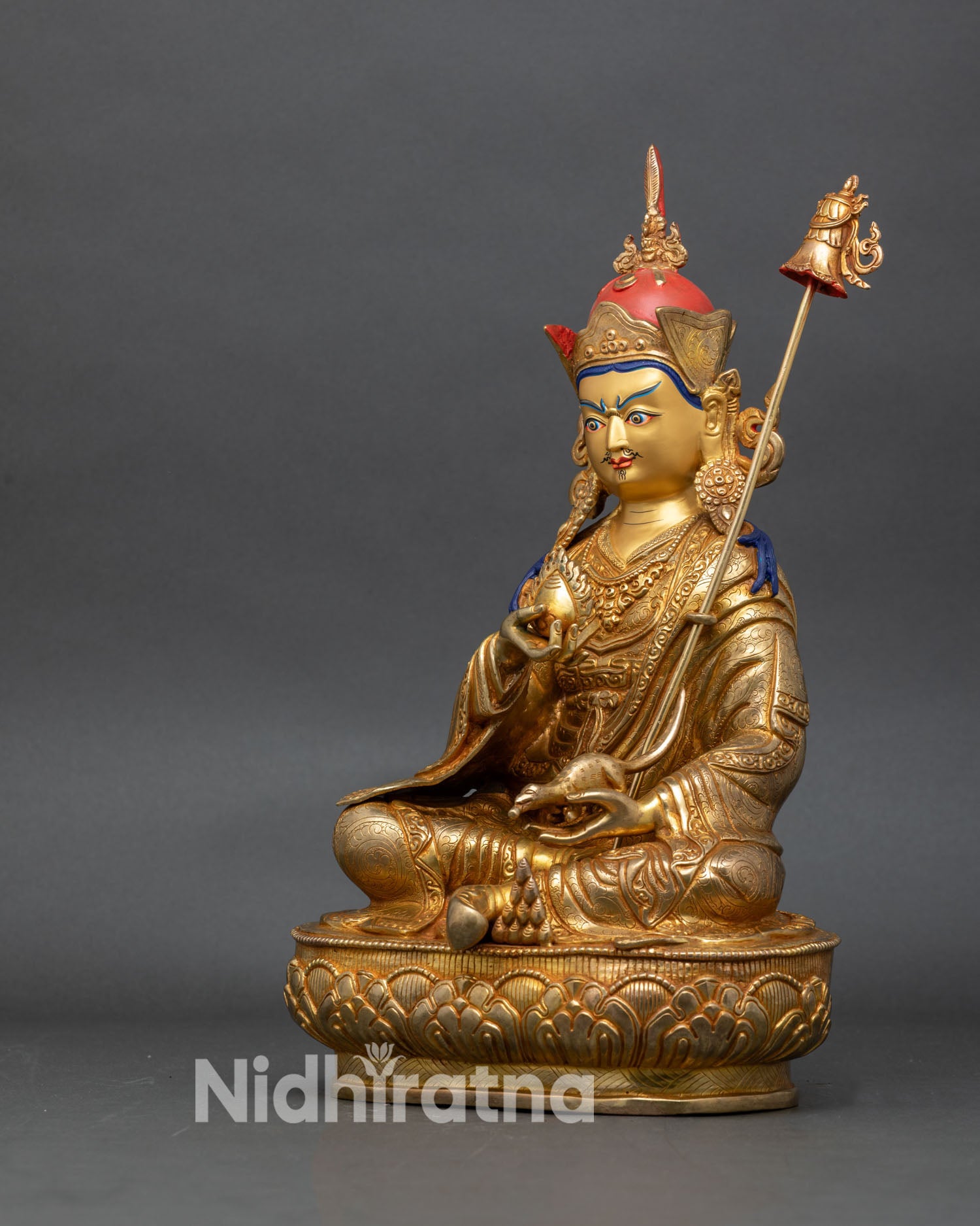 left side view of guru norlha statue showing intricate copper details and gold face