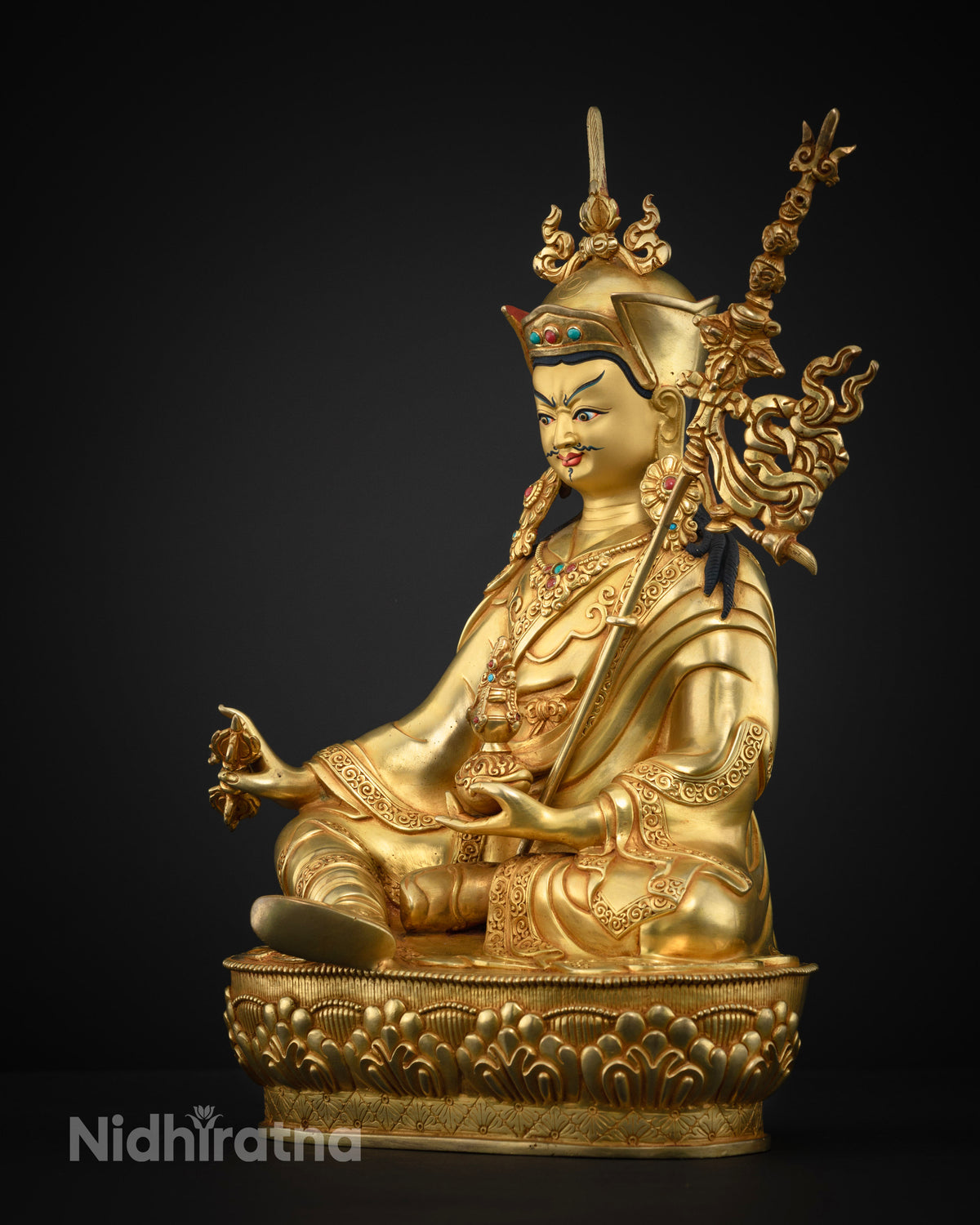 Left side view of Guru Rinpoche statue with kapala and khatvanga staff on Nepalese copper alloy