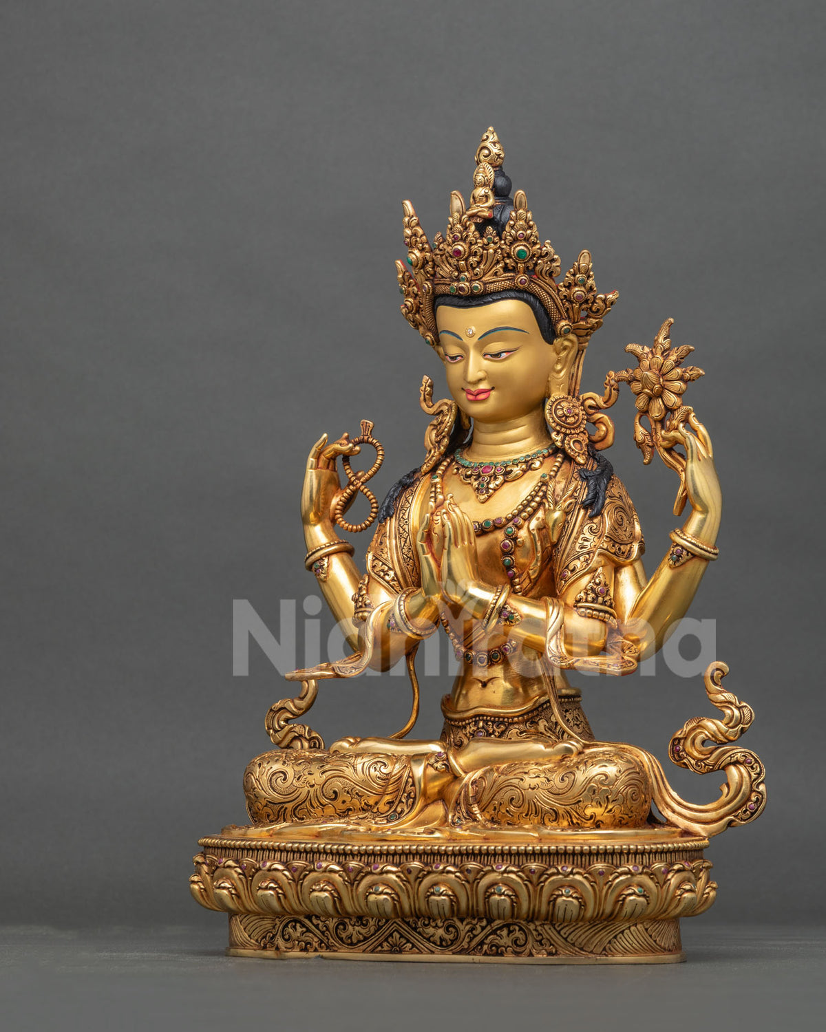 Left side view of hand-crafted gold Chenrezig statue on lotus throne.