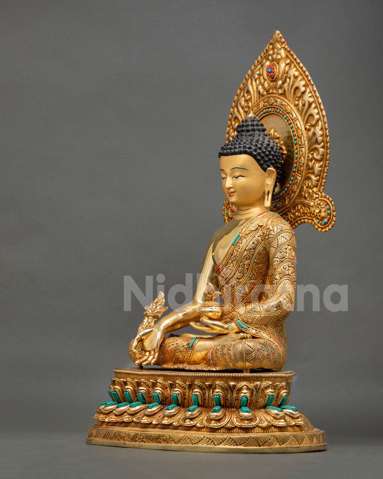 left side view of handcrafted medicine buddha sculpture with lotus seat and halo