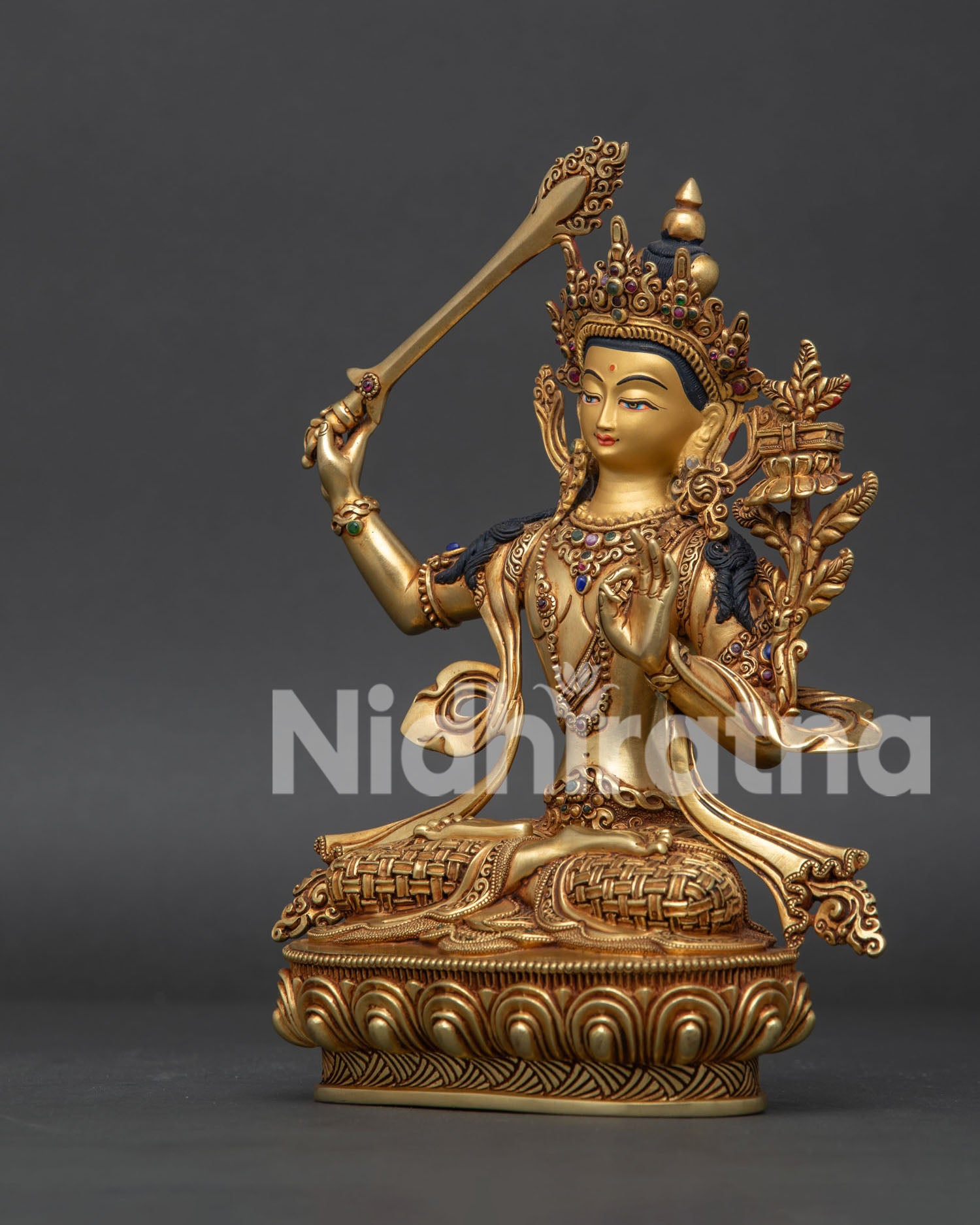 Left side view of Manjushri statue with gold gilded details and traditional Buddhist art