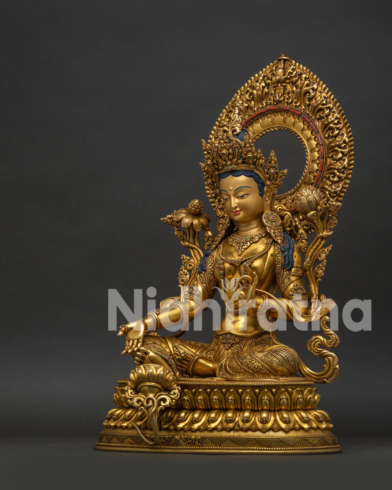 Left side view of Nepalese Green Tara Statue holding blooming utpala flower
