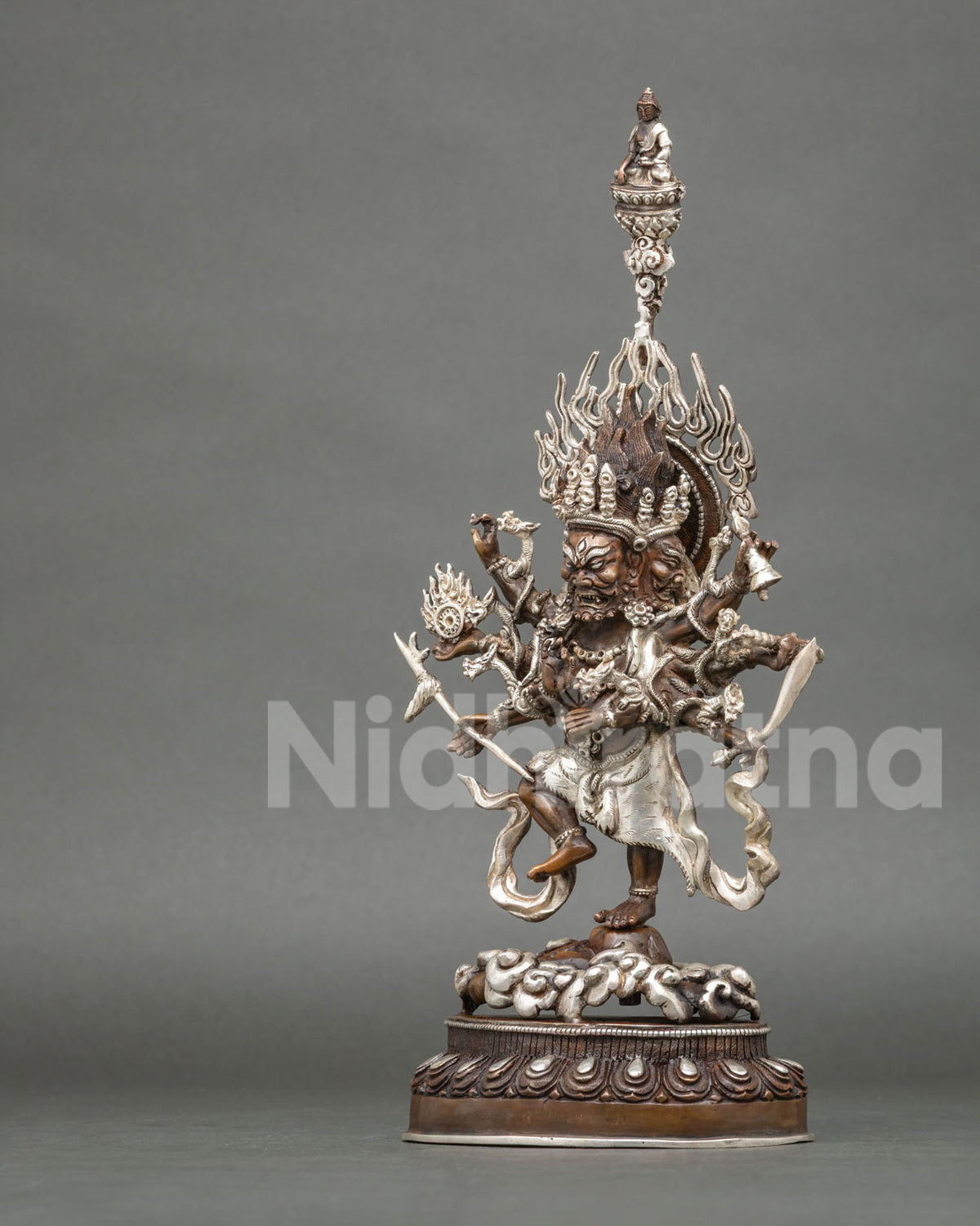 Left side view of oxidized copper Ucchusma statue standing on a lotus pedestal with silver detailing
