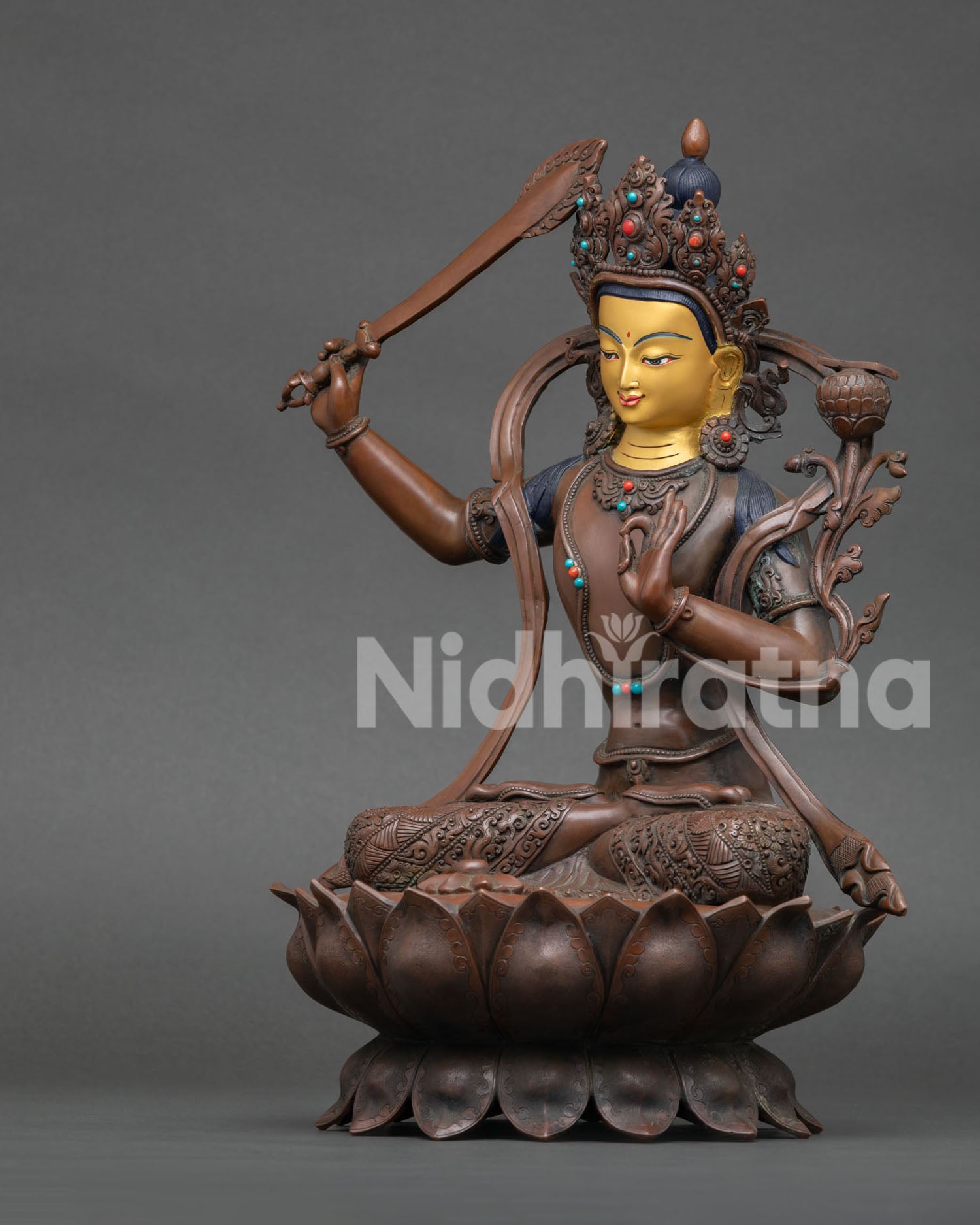left side view of oxidized manjushri statue with sacred lotus base
