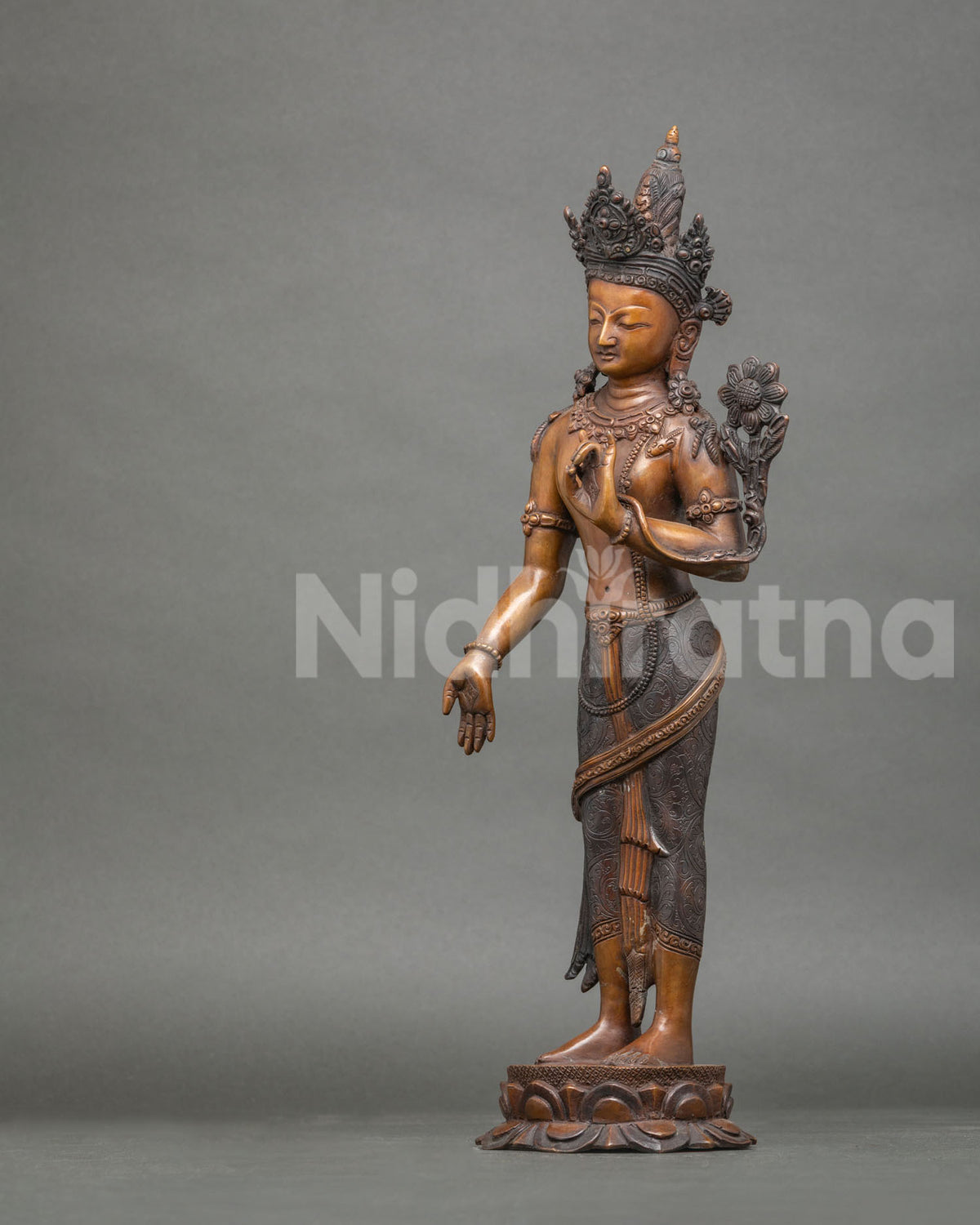 Left side view of Padmapani Bodhisattva statue holding Utpala flower on a lotus base, copper