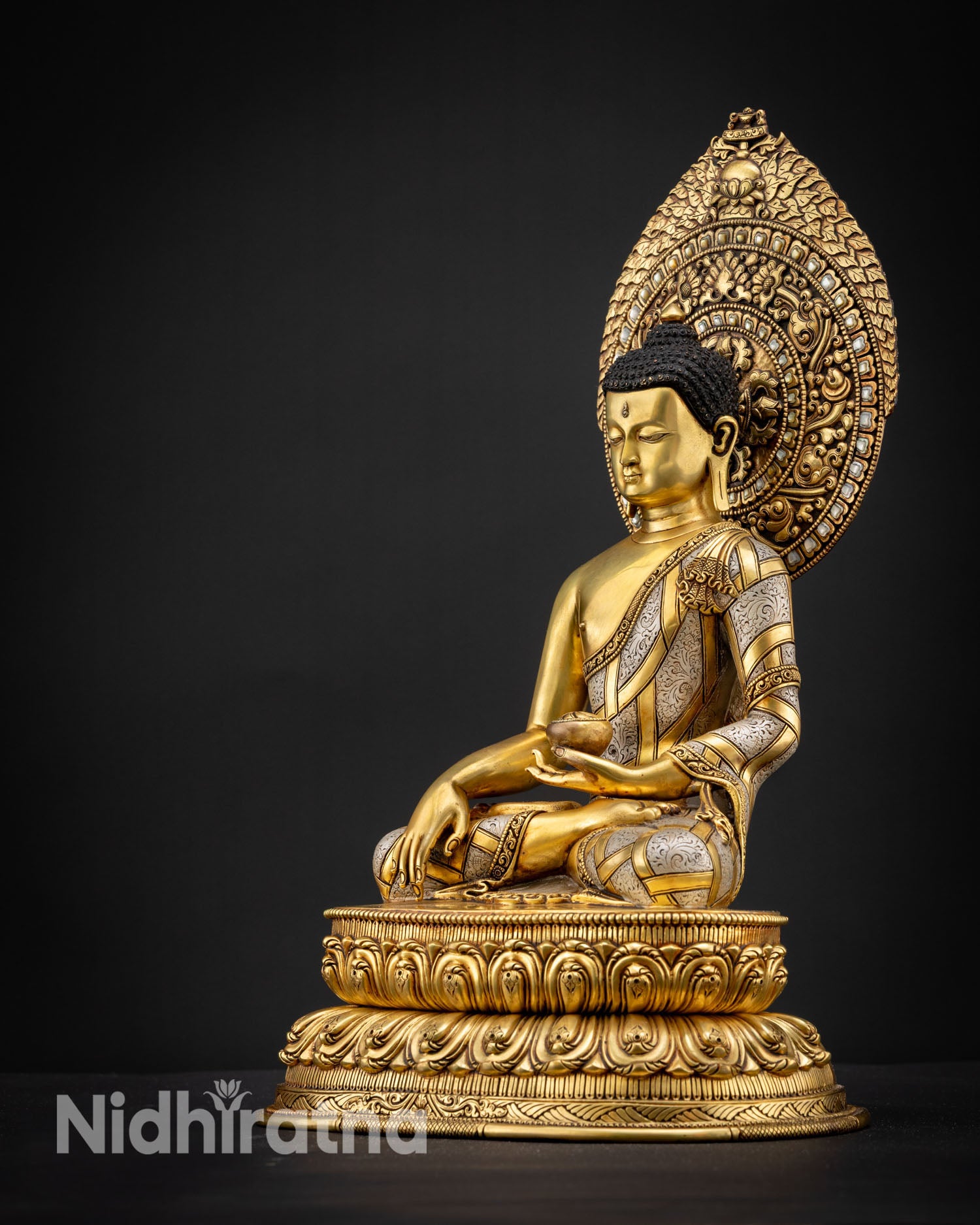 Left side view of Shakyamuni Buddha statue showing detailed copper craftsmanship with gold fire gilded finish and serene meditative posture on double layered lotus pedestal