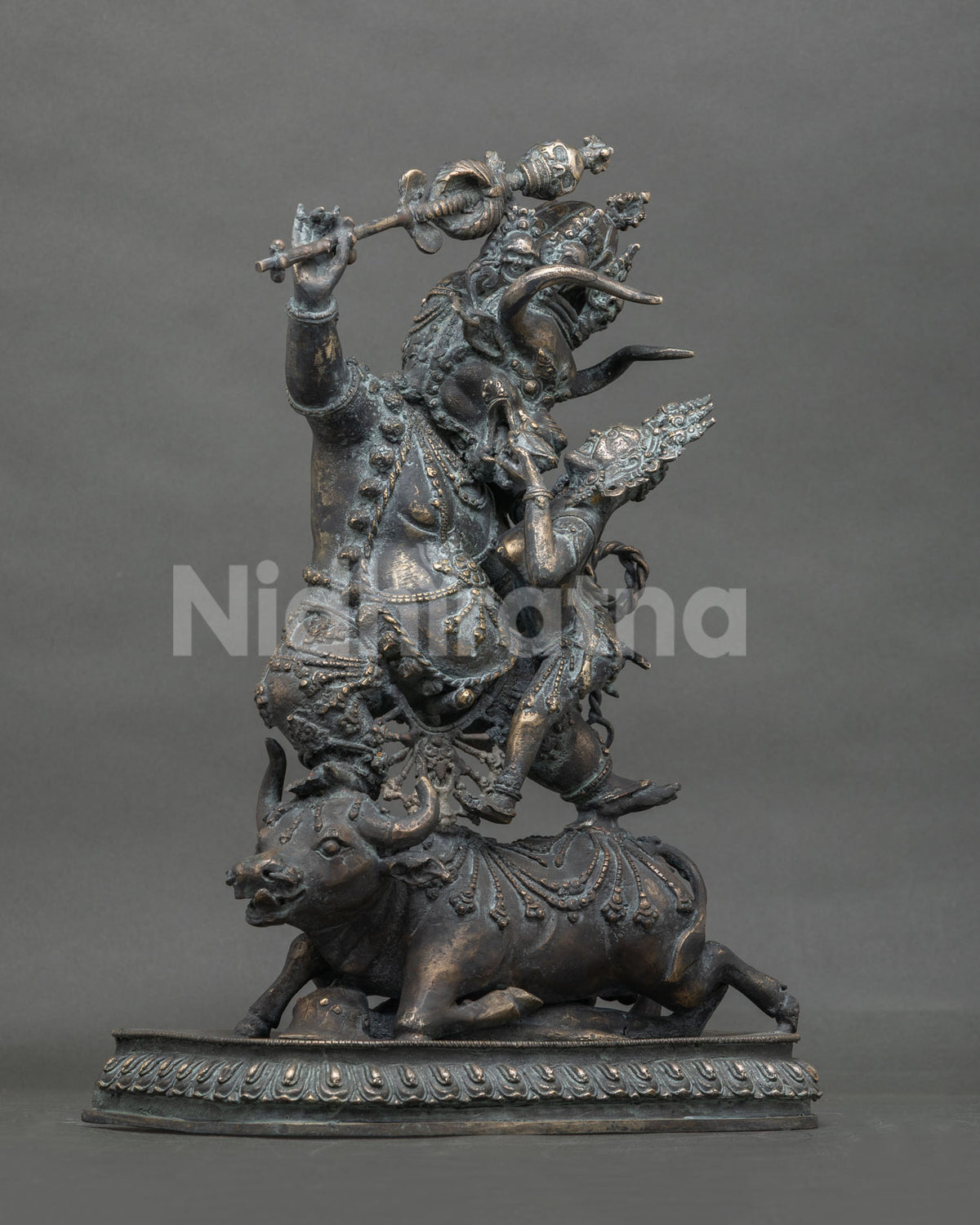 Left side view of Yamantaka Vajrabhairava bronze statue with raised khatvanga staff and buffalo base