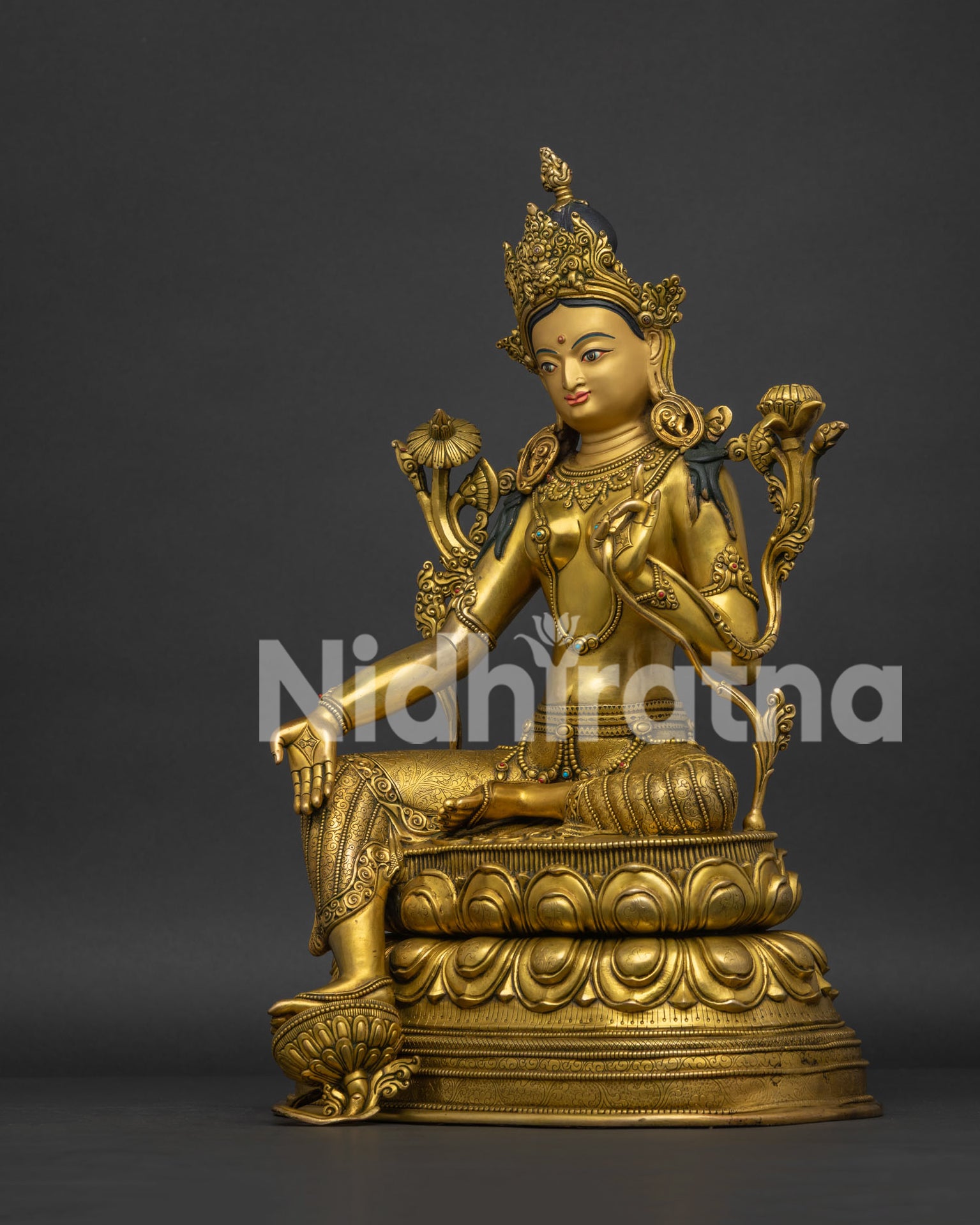 Left view of Buddhist Tara sculpture holding lotus stem in Lalitasana posture.