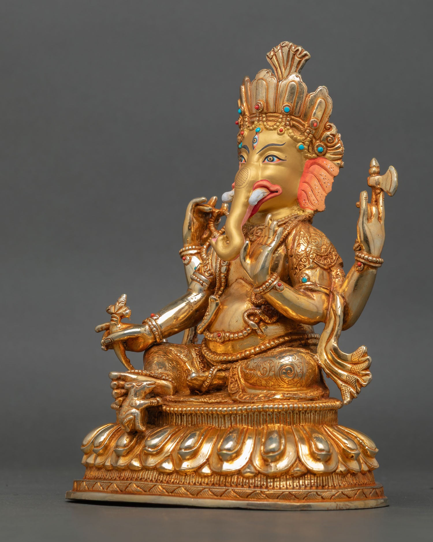 left view of elephant god ganesha statue with symbolic attributes and lotus base