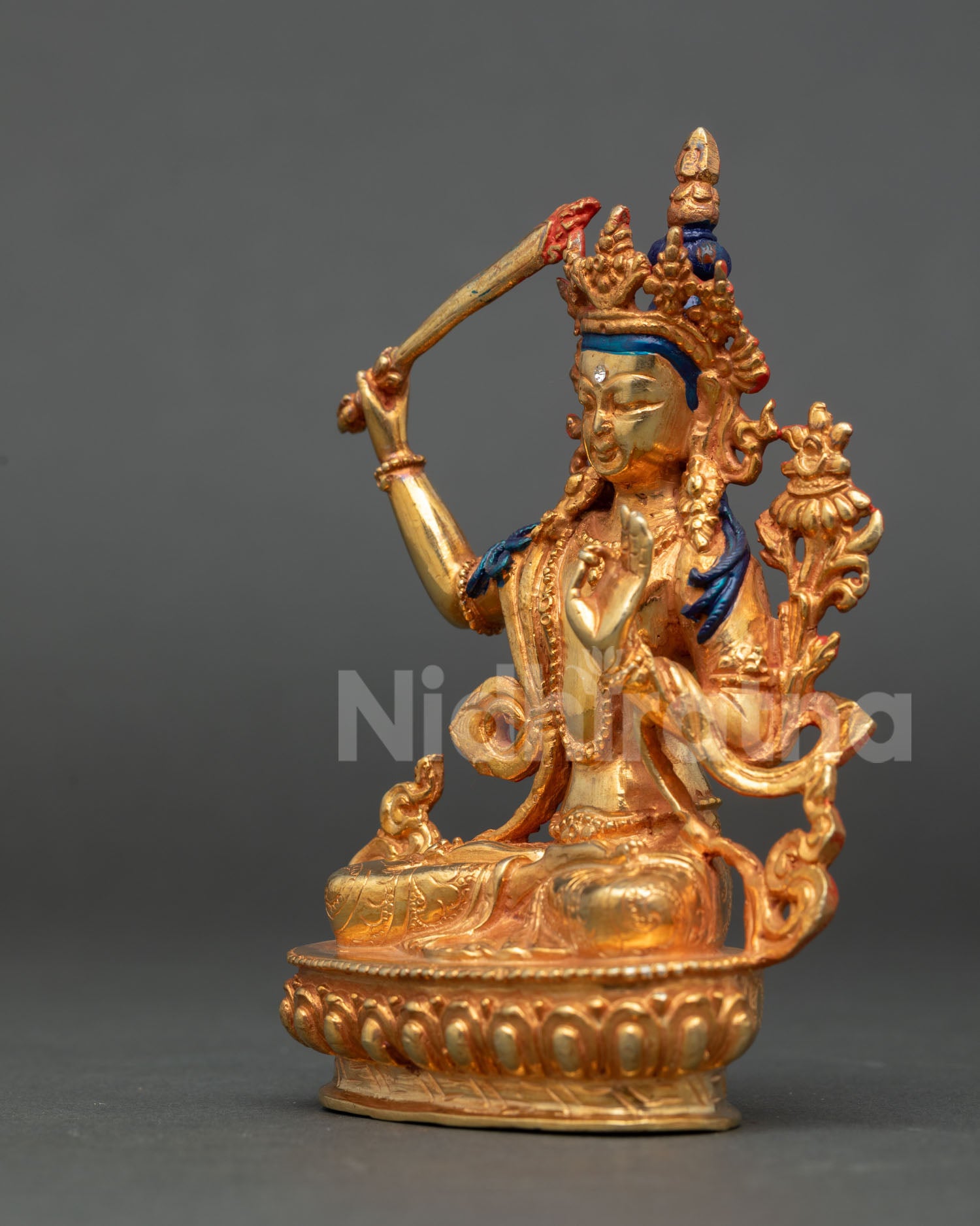 left view of handmade manjushri buddhist statue with utpala flower