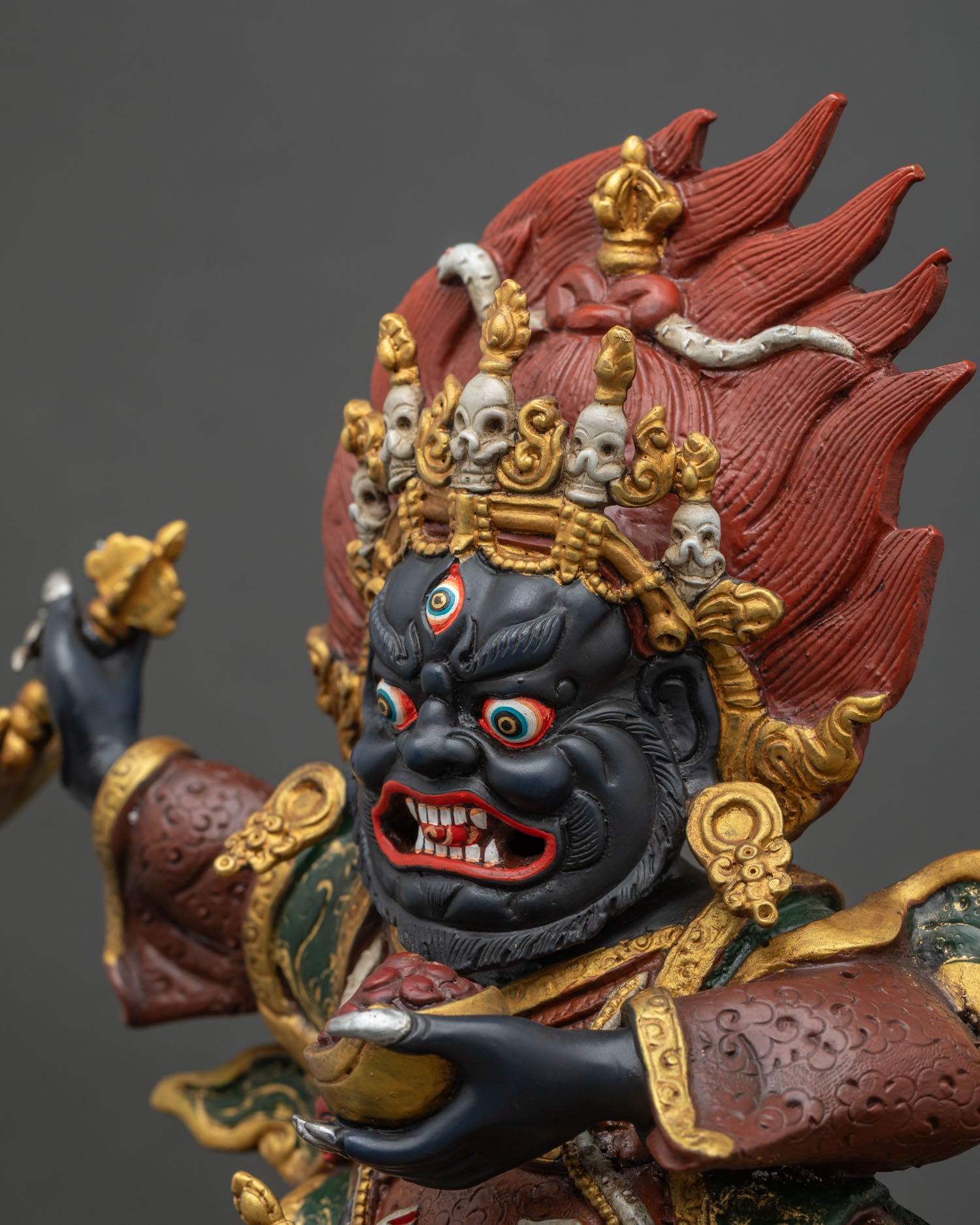Detailed side close-up of Mahakala Bernagchen statue with serpent and jewelry carvings