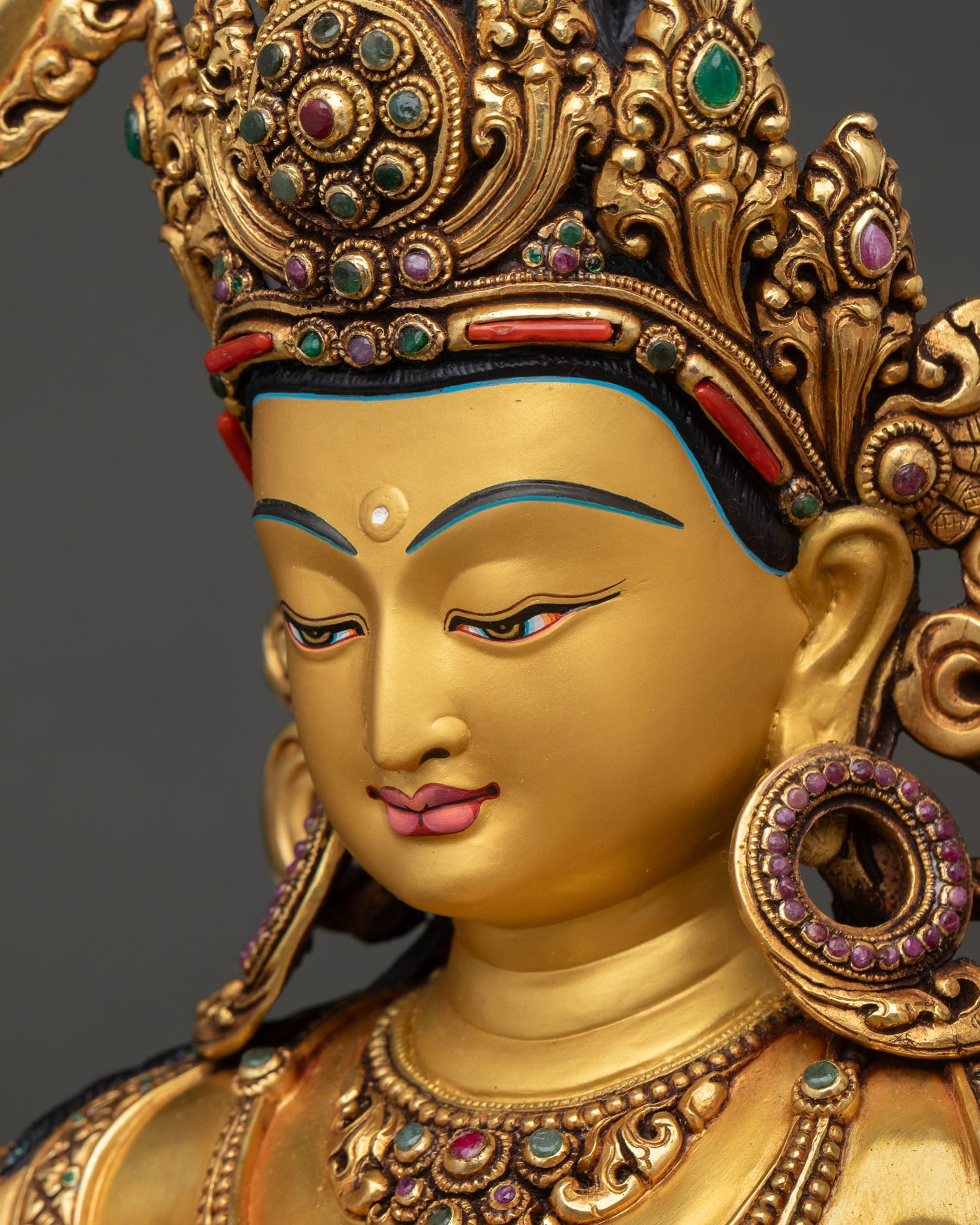 Detailed side close up face: side face view Manjushri bodhisattva gold face crown jewels serene expression