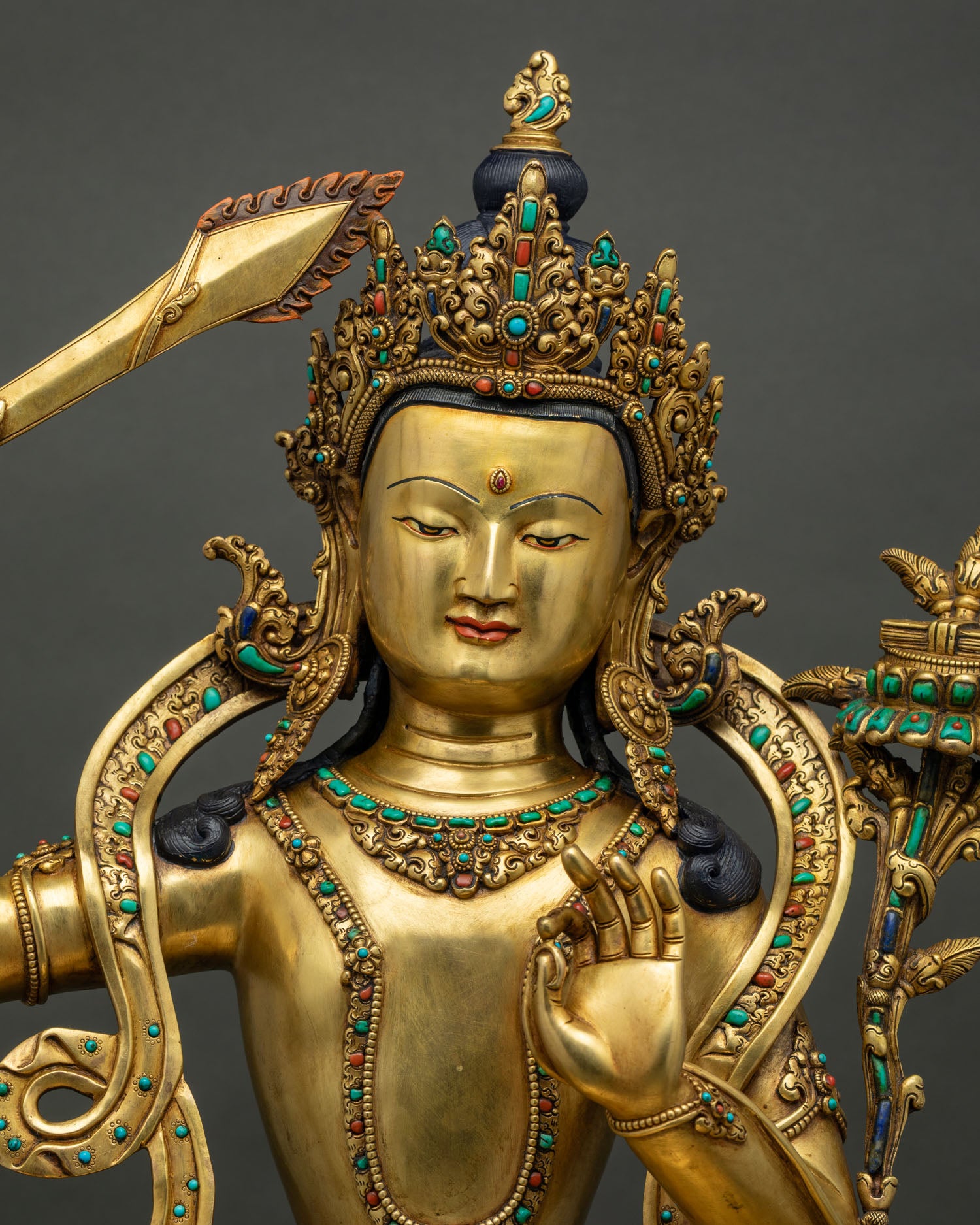 Manjushri Bodhisattva statue close up, 24K gold gilded copper with turquoise and coral inlay, Nepal