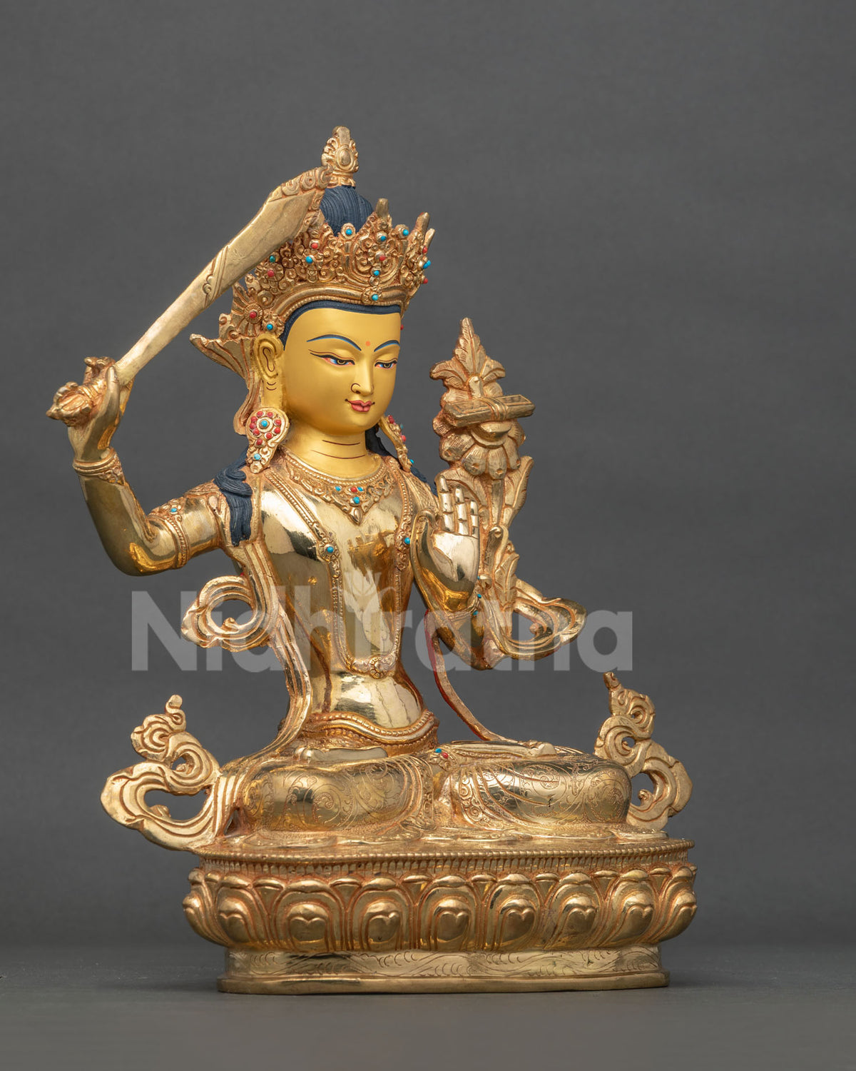 Manjushri Bodhisattva statue with flaming sword and lotus pedestal.