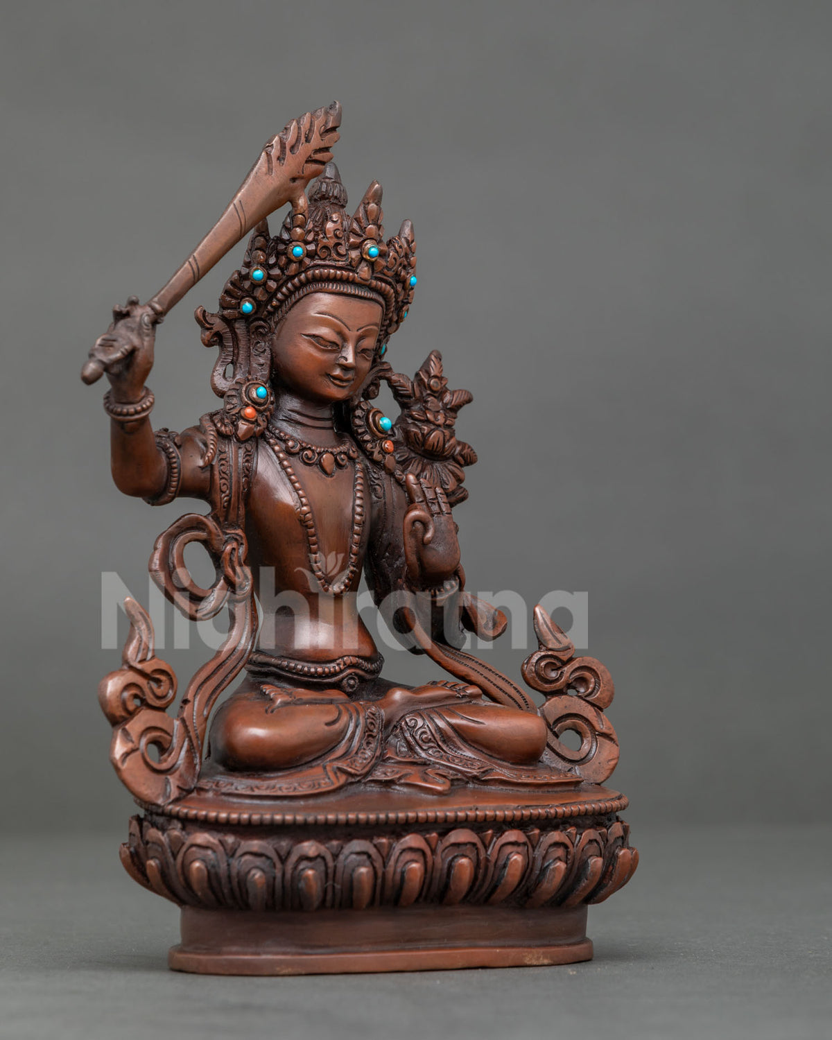Manjushri seated on lotus pedestal holding flaming wisdom sword.