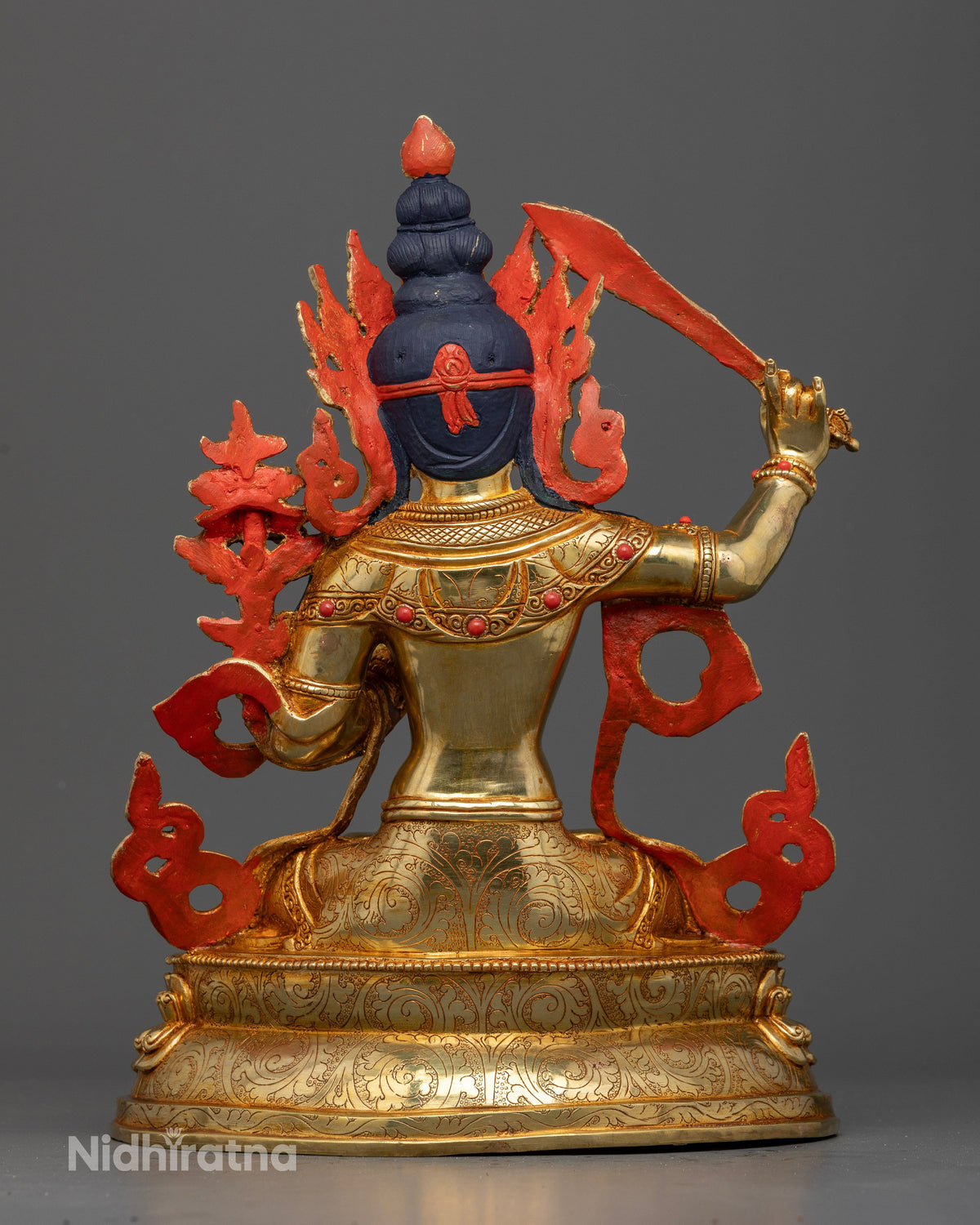 Manjushri statue back view Newari copper sculpture gold fire gilded ornate crown carved details.