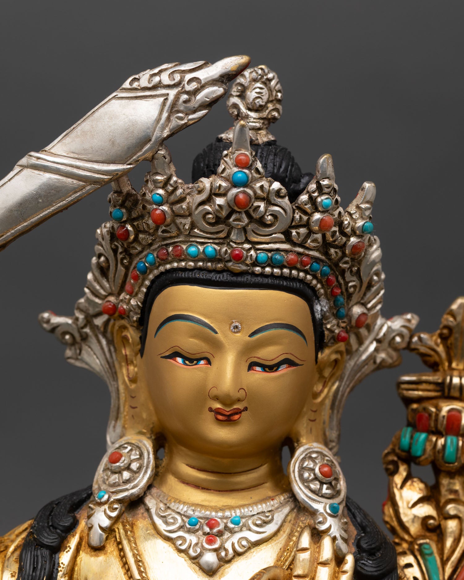 manjushri statue close up, handcrafted lost wax copper with gold gilding detail