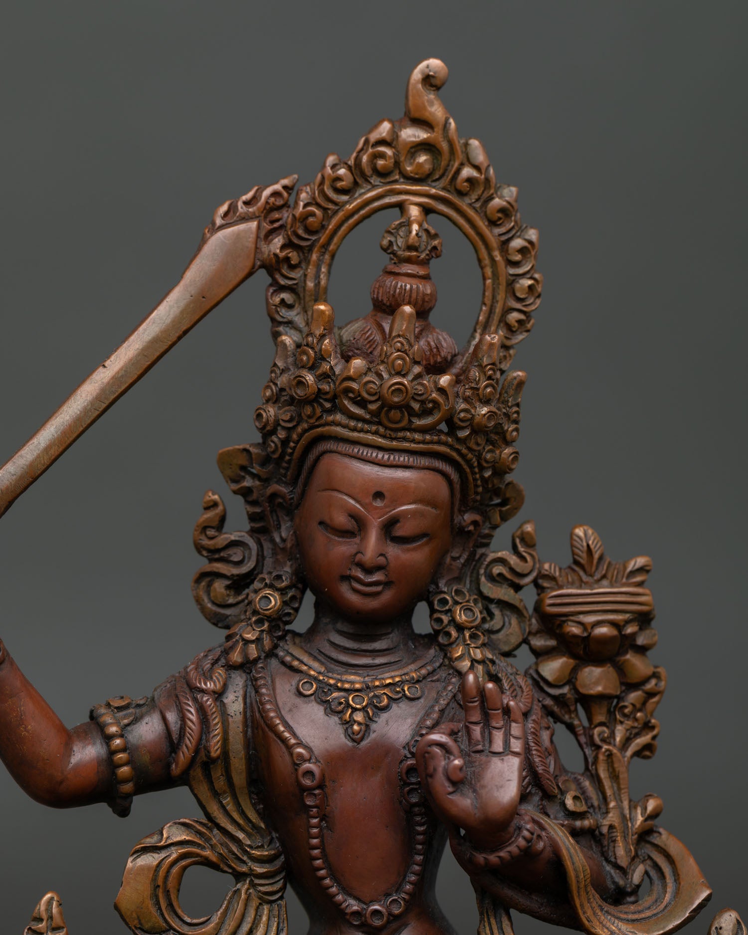 Manjushri statue close up handcrafted oxidized copper Buddhist sculpture.