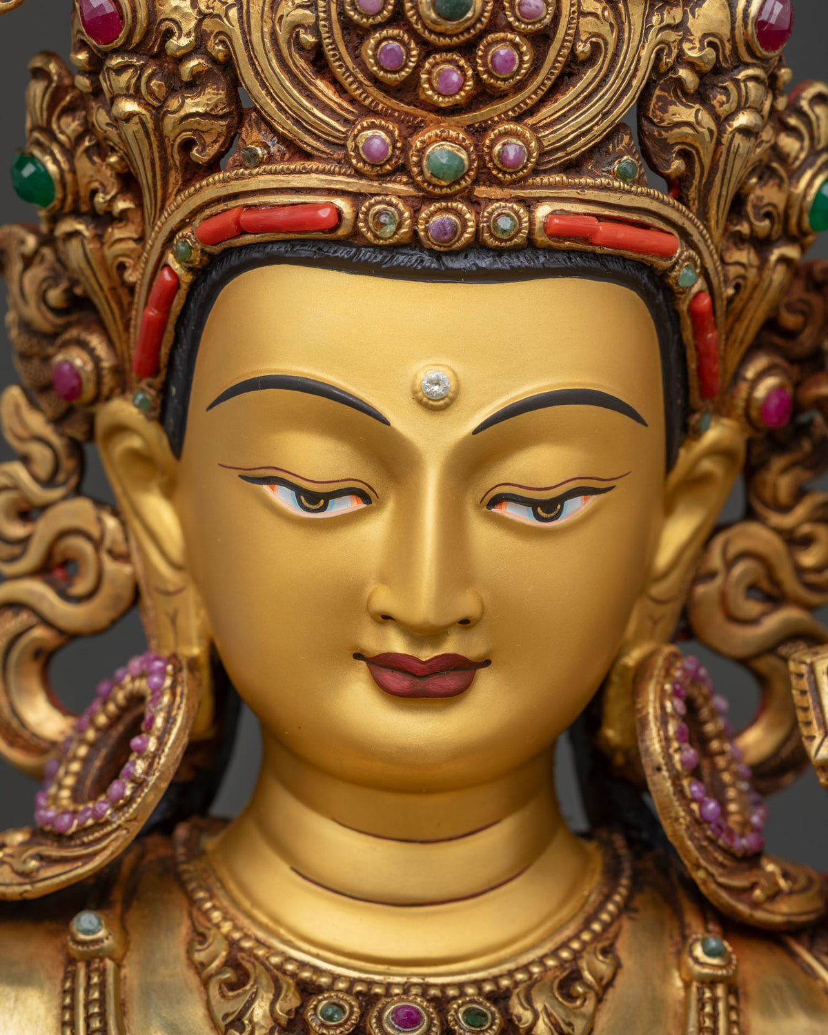 Manjushri Statue face close-up, gold-painted gold expression of wisdom and calm