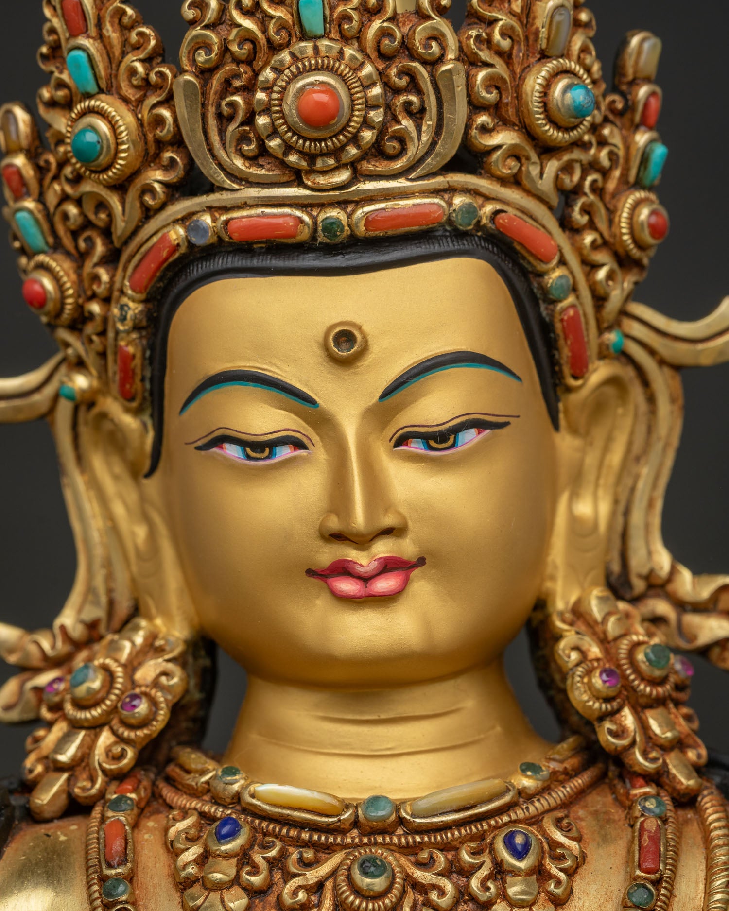 Manjushri statue gold-painted face close-up with five-jeweled crown and turquoise detailing