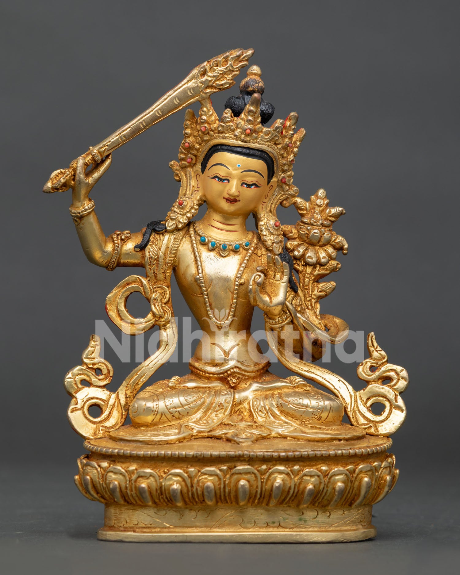 Manjushri statue holding flaming sword and prajnaparamita scripture on lotus throne.