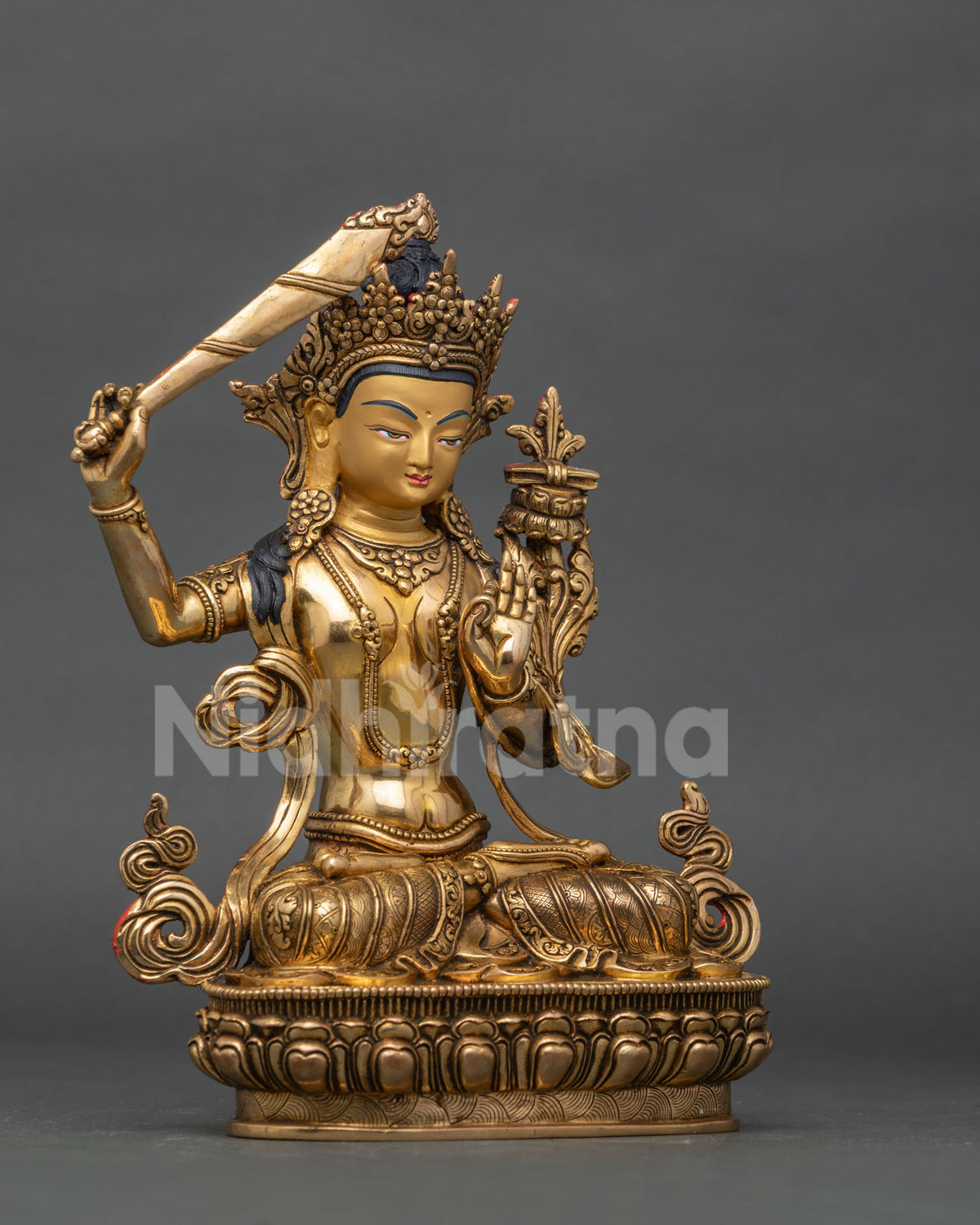 Manjushri statue holding flaming sword of wisdom and prajnaparamita sutra.