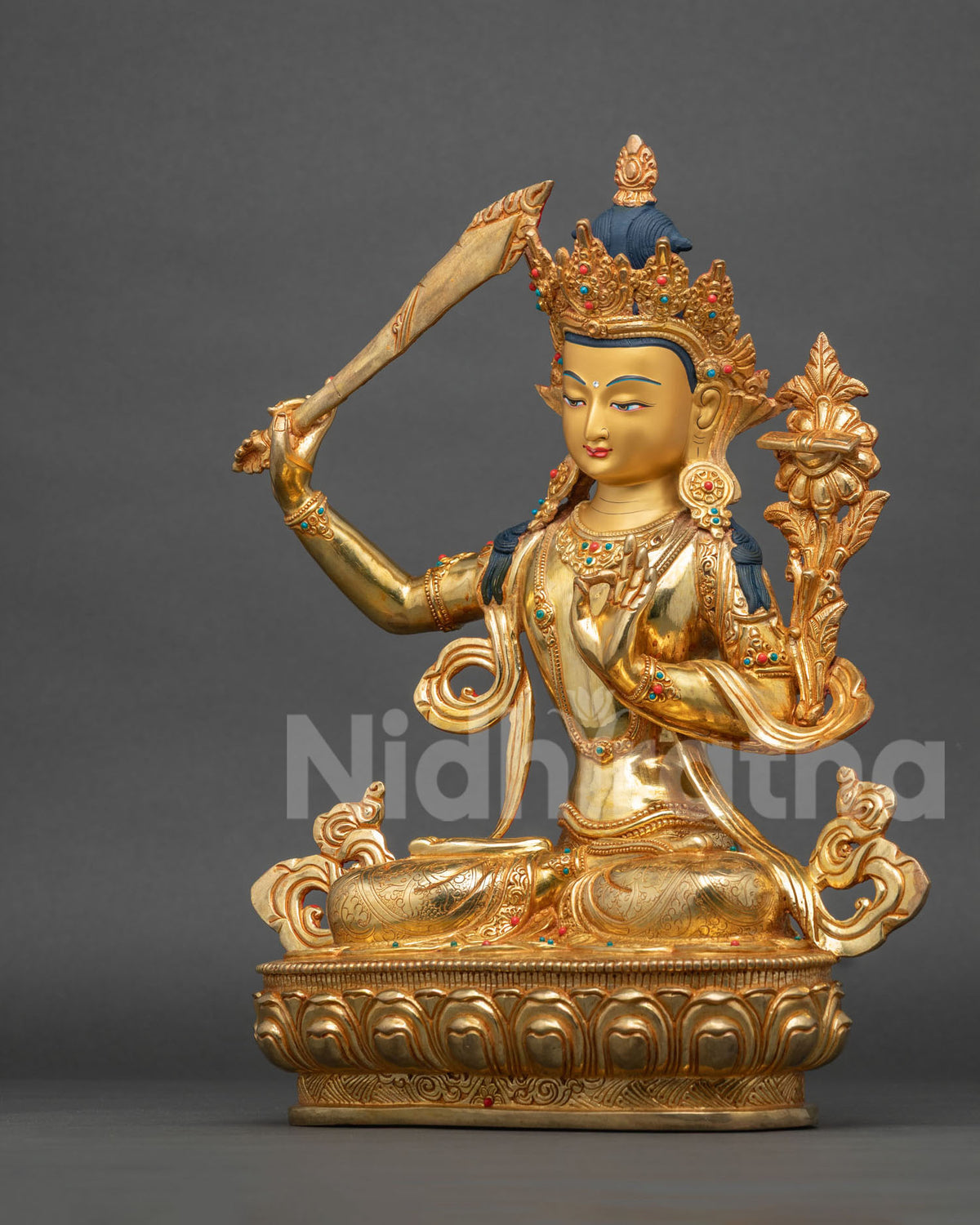 Manjushri statue seated on hand carved lotus pedestal left side view.