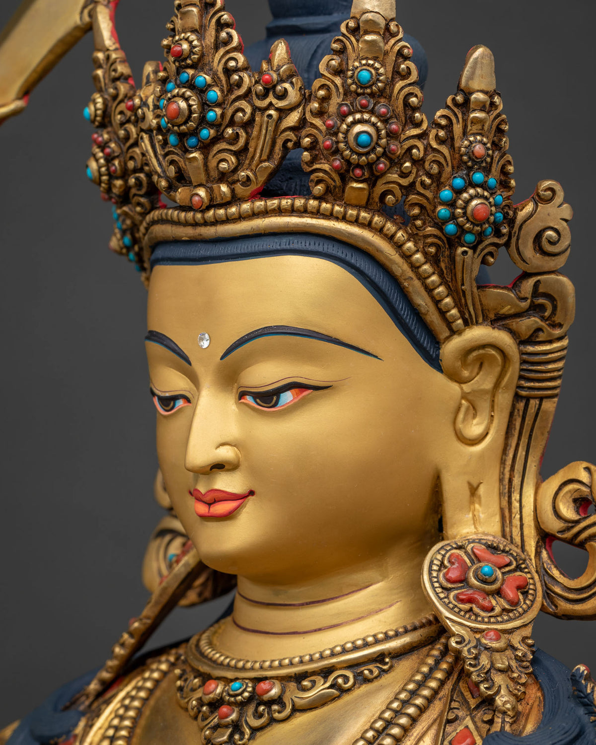 Manjushri Statue side profile face close-up, gold-painted wisdom expression