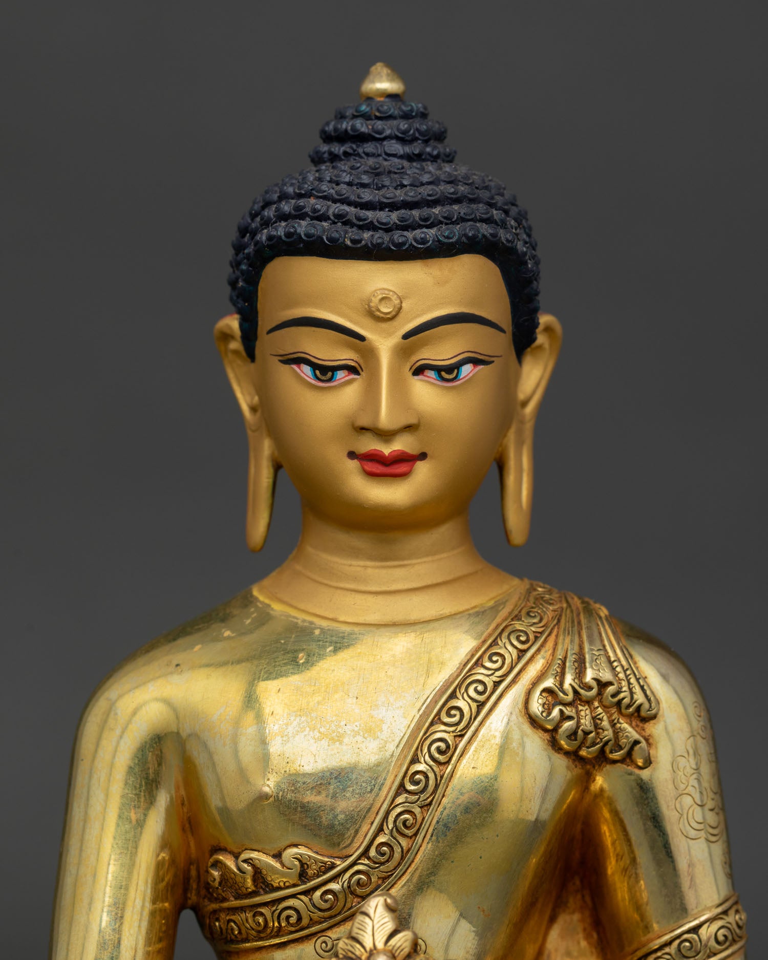 Medicine Buddha statue close up, detailed copper craftsmanship with gold painted sacred features