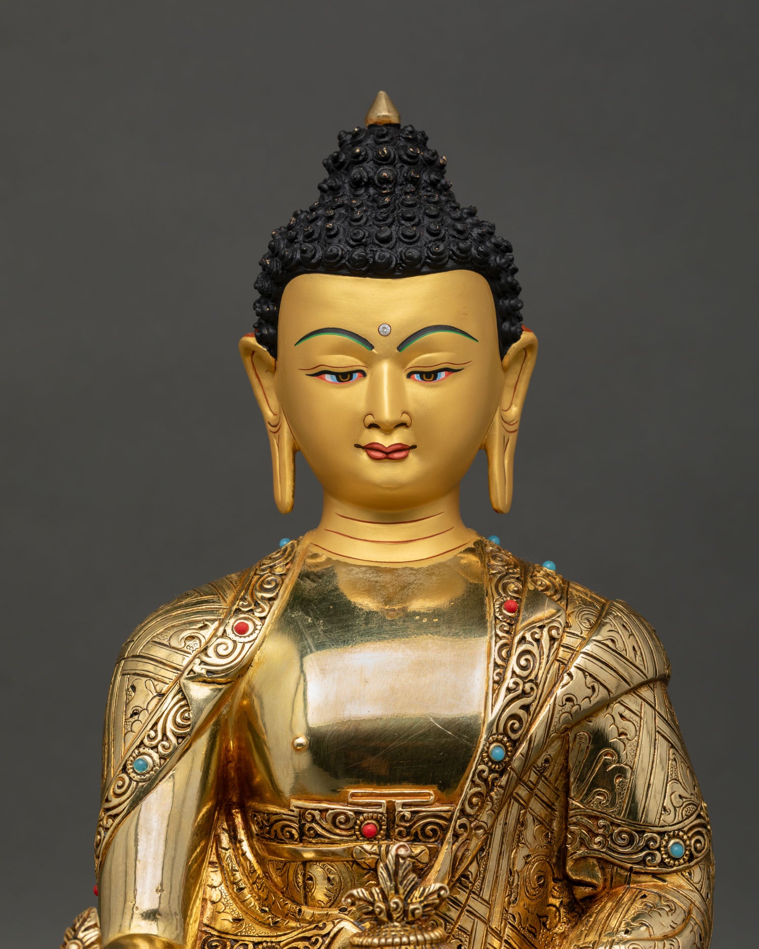 Medicine Buddha statue close up, handcrafted copper and gold gilded Bhaisajyaguru with fine engraved detailing