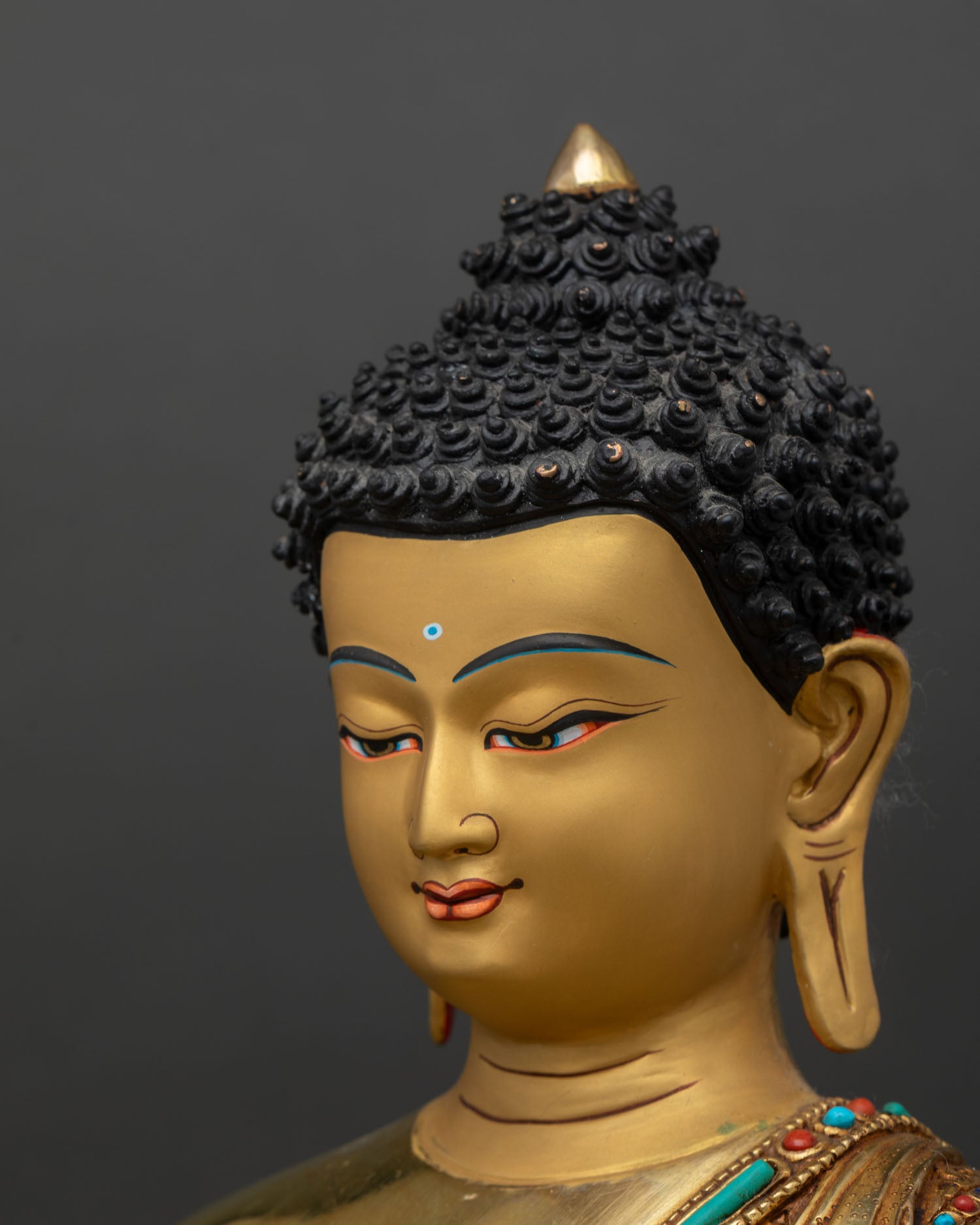 Medicine Buddha statue side face close up, serene Medicine Buddha expression with gold painted facial detailing Nepal art